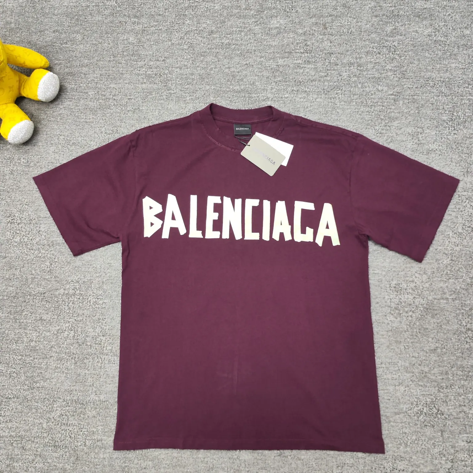 [Breaking new arrival] Top quality BALENCIAGA Paris spring and summer latest tape print washed and worn male and female couple star same style short sleeves 23ss tape tye black retro plain fabric medium version short sleeves Paris' new season's products have added the elements of artistic tape stickers, hot rhinestones and post-it notes, changing the previous minimalist printing style, this time the creativity is really laborious. The micro-OS style is friendly to both men and women. The fixed yarn and washed cotton are soft and waxy and resistant to damage. The slightly distressed worn details are a no-brainer for me who likes 𝐕𝐢𝐧𝐭𝐚𝐠𝐞. There are two styles of front and back printing. The front is like paper tape, and the back is a bright yellow graffiti painting effect, which has a strong impact on people. It looks great with denim overalls, and it’s super cool for girls to wear it with their lower body missing. Original custom-woven and dyed pure cotton material, heavily distressed. Counter 1/1; This product has a unisex design. The same oversize version for men and women·Tape Type logo on the front and back. It is characterized by heavy wear and washable effect. Color: Burgundy P; 140 Size: XS-L