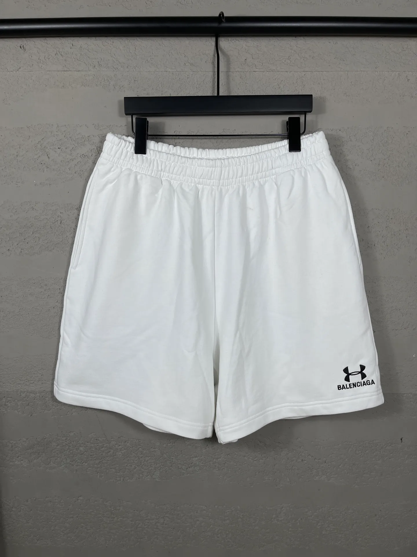 🅿️210 real photos [Top version. Official website quality] BALENCI*GA/Paris. 2025 new model. New embroidered shorts co-branded by Under Armor in Paris. Synchronized with brick cabinets. Developed as genuine products at the first time, please print and compare! The fabric is made of Paris ZP custom-woven and dyed 100% cotton terry sweatshirt. The weight is 460 grams. The cloth surface is clean. The cloth pattern is clear and the hand feels soft and comfortable. The embroidery uses an imported Tajima embroidery machine. The letters are clear and the effect is three-dimensional. The version adopts a loose version. Same style for men and women. Code: BL257003 Color: black, white Size: XS S M L