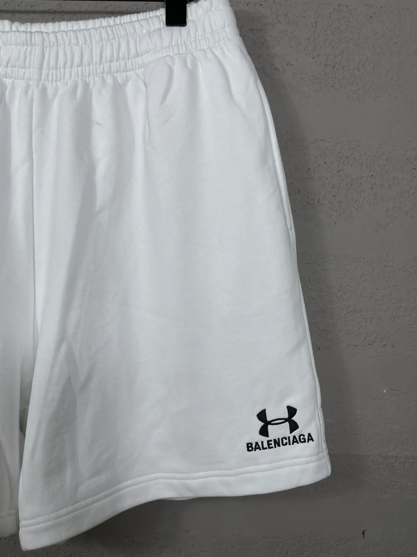 🅿️210 real photos [Top version. Official website quality] BALENCI*GA/Paris. 2025 new model. New embroidered shorts co-branded by Under Armor in Paris. Synchronized with brick cabinets. Developed as genuine products at the first time, please print and compare! The fabric is made of Paris ZP custom-woven and dyed 100% cotton terry sweatshirt. The weight is 460 grams. The cloth surface is clean. The cloth pattern is clear and the hand feels soft and comfortable. The embroidery uses an imported Tajima embroidery machine. The letters are clear and the effect is three-dimensional. The version adopts a loose version. Same style for men and women. Code: BL257003 Color: black, white Size: XS S M L