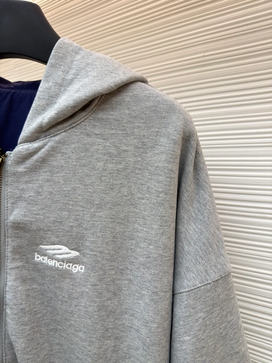 Balenciaga double-sided long-sleeved zipper jacket ●Original version: purchased and developed by 16318 ●Item number: 1681852-B70 ●Fabric: cotton fabric ●Technology: embroidery production ●Color: gray/blue ●Version: fitted version ●Weight: about 1395 grams ●Size: XS-S-M-L ●Description: These two hooded jackets adopt a double-sided design. One side is made of navy blue light nylon fabric (windproof and wear-resistant), and the other side is light gray fleece knitted (skin-friendly and warm), allowing one garment to be adapted to multiple scenes. In terms of craftsmanship, the body adopts a full zipper closure + hooded one-piece tailoring, and contrasting decorative stitching is added to the shoulders and side seams to enhance the style. The cuffs and hem are elasticated to provide both comfort and windproofness. In the details, the body is embroidered with the brand logo, and the sizes cover XS-L. The manual measurement data is accurate (error 1-2CM). The style is loose and off-shoulder, suitable for daily casual wear. The overall wiring is straight and delicate, the fabric is comfortable and soft, and the color is consistent without color difference. It can be matched with the same style to create a fashionable look and control various occasions. Customized accessories, complete with three standards, same style for men and women!
