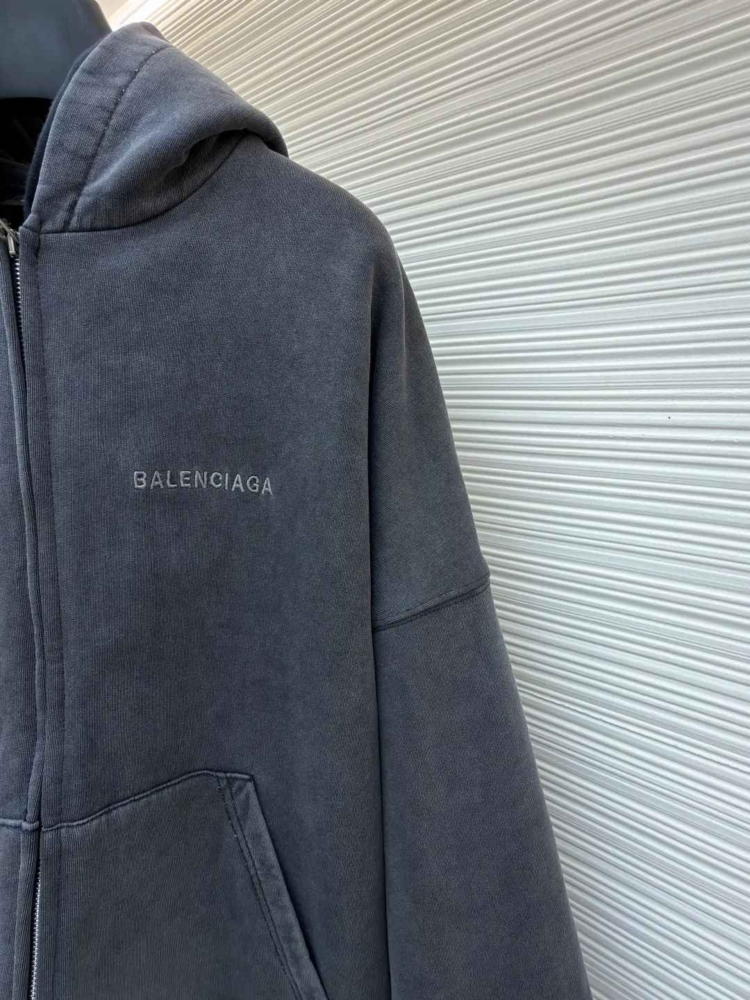 Balenciaga laminated cola zipper hooded faded jacket ●Original version: Purchased and developed by 15689 ●Item number: 1682490-D90 ●Fabric: 100% cotton ●Technology: Washed and faded ●Color: Washed gray ●Version: loose fit ●Weight: approximately 1785 grams ●Size: XS-S-M-L ●Description: This Balenciaga fake two-piece hooded zipper jacket is made of high-weight washed cotton as the outer layer. It is processed by stonewashing. The fabric has an aged gray texture, is soft and not easy to pilling and deformation. The inner layer is spliced with gray fleece fabric, and the double-layer structure improves warmth and layering. The front of the body is decorated with brand letter printing, which is made using offset printing technology. The pattern is clear and firm and will not easily crack or fall off. The overall design is oversized and loose. The double zipper opening and closing design enhances the flexibility of wearing. The zipper is made of customized metal material, which is smooth and durable. The hood has a crisp outline, the cuffs and hem are ribbed, and the elasticity is moderate and not easy to loosen. The pockets on both sides are embedded with craftsmanship. The wiring is straight and dense. The details show the brand's craftsmanship, making it easy to create a street style. The overall wiring is straight and delicate, the fabric is comfortable and soft, and the color is consistent without color difference. It can be matched with the same style to create a fashionable look and control various occasions. Customized accessories, complete with three standards, same style for men and women!