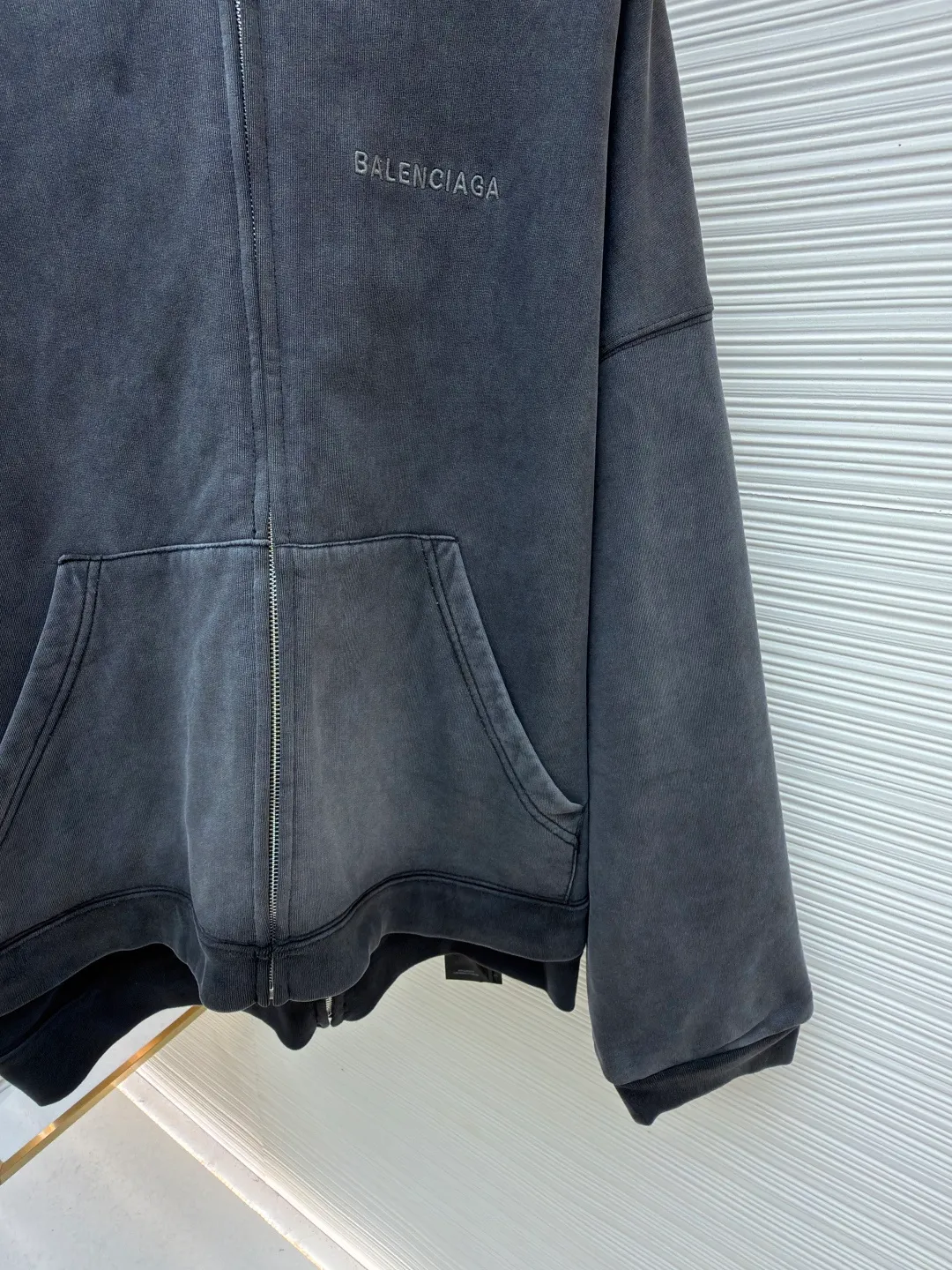 Balenciaga laminated cola zipper hooded faded jacket ●Original version: Purchased and developed by 15689 ●Item number: 1682490-D90 ●Fabric: 100% cotton ●Technology: Washed and faded ●Color: Washed gray ●Version: loose fit ●Weight: approximately 1785 grams ●Size: XS-S-M-L ●Description: This Balenciaga fake two-piece hooded zipper jacket is made of high-weight washed cotton as the outer layer. It is processed by stonewashing. The fabric has an aged gray texture, is soft and not easy to pilling and deformation. The inner layer is spliced with gray fleece fabric, and the double-layer structure improves warmth and layering. The front of the body is decorated with brand letter printing, which is made using offset printing technology. The pattern is clear and firm and will not easily crack or fall off. The overall design is oversized and loose. The double zipper opening and closing design enhances the flexibility of wearing. The zipper is made of customized metal material, which is smooth and durable. The hood has a crisp outline, the cuffs and hem are ribbed, and the elasticity is moderate and not easy to loosen. The pockets on both sides are embedded with craftsmanship. The wiring is straight and dense. The details show the brand's craftsmanship, making it easy to create a street style. The overall wiring is straight and delicate, the fabric is comfortable and soft, and the color is consistent without color difference. It can be matched with the same style to create a fashionable look and control various occasions. Customized accessories, complete with three standards, same style for men and women!