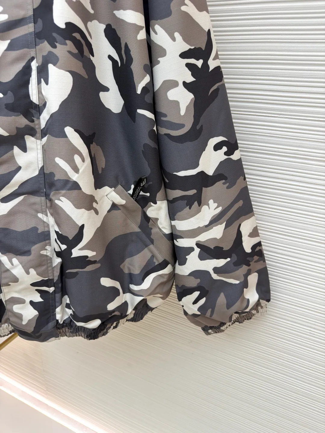 Balenciaga Camouflage Ski Series·Flight Jacket ●Original version: Purchased and developed by 22527 ●Item number: 1681684-E85 ●Fabric: Technical waterproof fabric ●Technology: Positioning cutting machine production ●Color: Gray ●Version: Loose version ●Weight: about 1485 grams ●Size: XS-S-M-L ●Description: The fabric uses advanced waterproof technology to effectively resist moisture penetration. The outer layer is equipped with camouflage pattern design. By utilizing the tight weaving of microfiber and adding a waterproof coating inside the fabric, the inner and outer double-layer waterproof and windproof functions are achieved. The interweaving method and density of the fabric's 7*8 plaid warp and weft yarns are precisely controlled to form a specific plaid pattern; to ensure the uniformity and stability of the fabric. The surface forms an obvious concave and convex texture, thereby enhancing the three-dimensional sense of the fabric. The plaid design not only makes the fabric more visually beautiful, but also enhances the structural stability and durability of the fabric. This fabric is a special structural material used to prevent ice and snow from accumulating and penetrating. It has excellent elasticity to ensure a tight fit and prevent ice and snow from penetrating. The material has been specially treated to have excellent wear resistance and can resist scratches and wear from sharp objects such as ice, snow, rocks, etc. The overall wiring is straight and delicate, the fabric is comfortable and soft, and the color is consistent without color difference. It can be matched with the same style to create a fashionable look and control various occasions. Customized accessories, complete with three standards, same style for men and women!