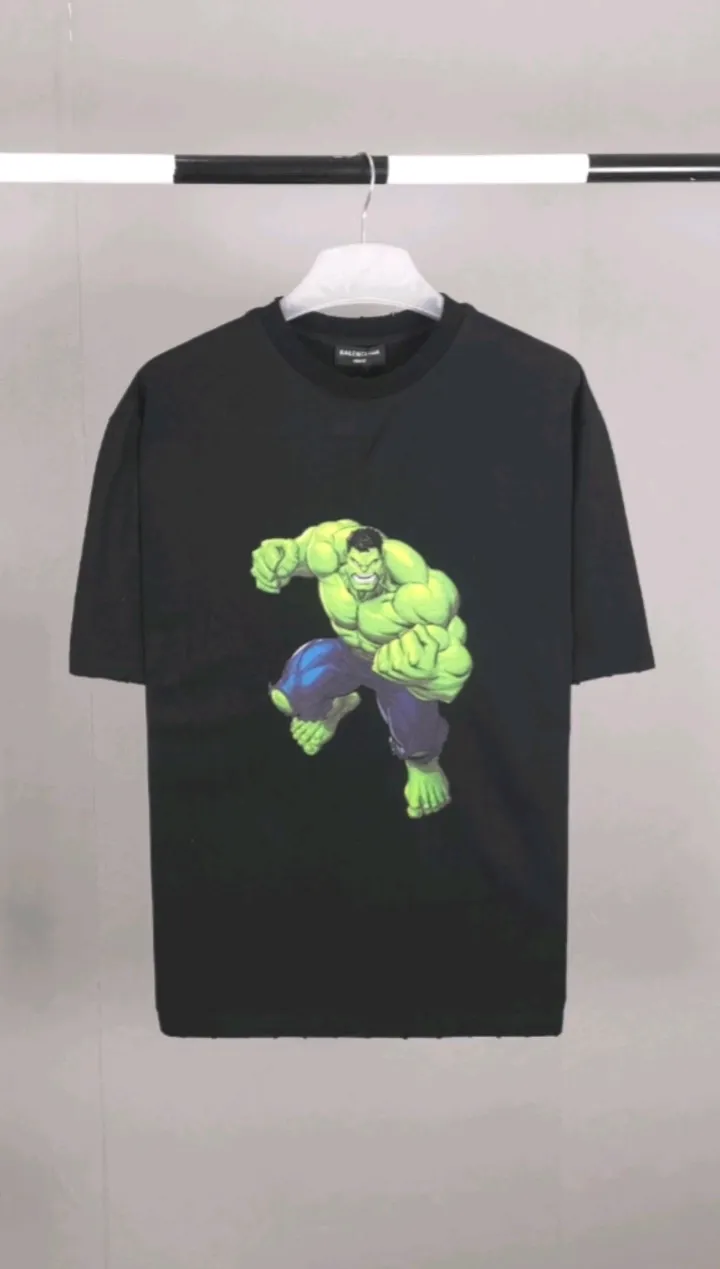 Real shot of the video————The strongest Balenciaga/Balenciaga Heavy Industry washed Hulk Marvel joint short-sleeved fabric is made of double yarn plain weave, 280g sweatshirt fabric; matched with 32S/1*2 fine cotton double yarn 1*1 rib, washed environmentally friendly custom-dyed fabric, and the threads are in the same vat with no color difference.  The front printed green giant uses water-wash printing technology; it is made of imported environmentally friendly glue material (no odor) and mechanized printing technology. Mechanical printing has high precision, the positioning accuracy can reach ±0.02mm, the quality is stable, and the printing quality is clear, just like the photo. The body is washed and frayed and embroidered elements are added, which greatly increases the interest of the clothing; it has a unique visual effect. The special washing effect creates a unique aged effect. A unisex style that blurs the boundaries, with a classic dropped shoulder and oversize silhouette, and a loose and casual upper body. Color: Black Size: XS-L P:260