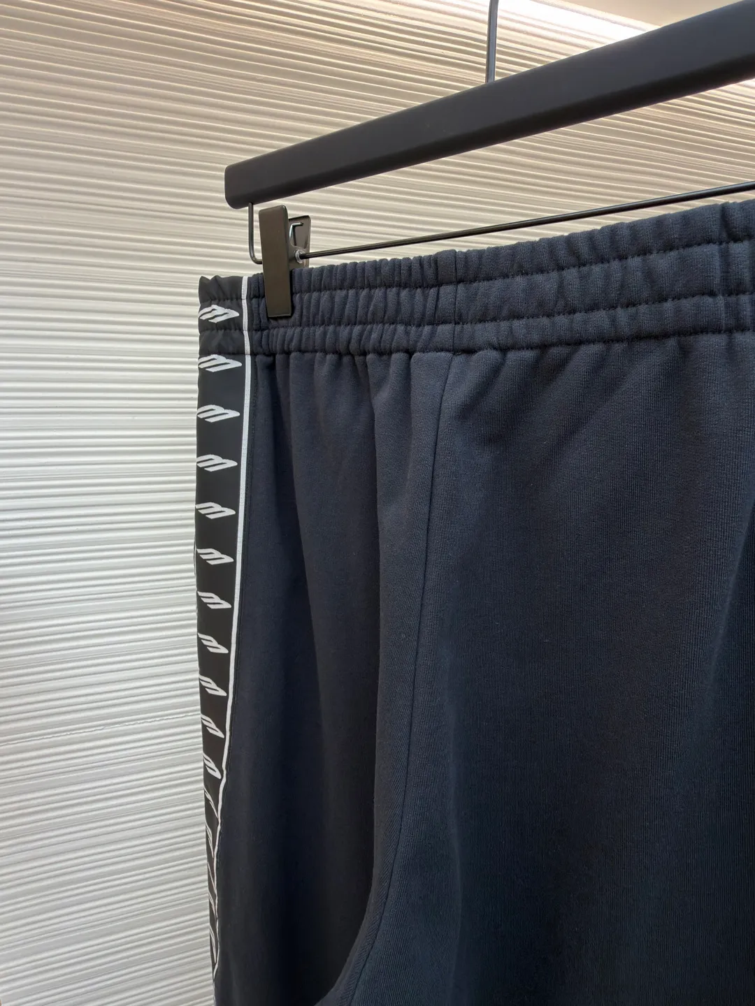 Balenciaga side webbing trousers ●Original version: Purchased and developed by 7858 ●Item number: 1682188-A95 ●Fabric: cotton fabric ●Technology: printing production ●Color: black ●Version: loose fit ●Weight: about 745 grams ●Size: XS-S-M-L ●Description: This black casual trousers with side straps shows ingenuity in craftsmanship. The trousers are made of high-density twill knitted fabric, which has undergone pre-shrunk treatment and high-temperature shaping process to ensure that the fabric is not easy to pill, deform and has an outstanding drape feeling. It also has good breathability and anti-wrinkle properties. The waist is designed with a high-elastic spandex drawstring, which is reinforced through precise four-line seaming technology. The drawstring perforations are equipped with metal air holes, which not only improves durability but also adds detailed texture. The side decorative belt is a custom-made jacquard webbing, woven with 72 stitches of high-density on a computerized jacquard machine. The pattern texture is clear and three-dimensional. The webbing and the trousers are spliced ​​together through a flat car synchronous sewing process. The stitches are even and fine and the spacing is controlled within 0.8cm, eliminating jumpers and off-thread problems. The trouser legs are hemmed using a seamless process and are reinforced with inner linings. The overall tailoring follows ergonomics and uses three-dimensional tailoring technology to make the trousers fit the body shape. Each process undergoes three quality control inspections. From fabric cutting to finished product sewing, dimensional accuracy and process details are strictly controlled throughout the process to create casual trousers with both texture and practical wearability. The overall wiring is straight and delicate, the fabric is comfortable and soft, and the color is consistent without color difference. It can be matched with the same style to create a fashionable look and control various occasions. Customized accessories, complete with three standards, same style for men and women!