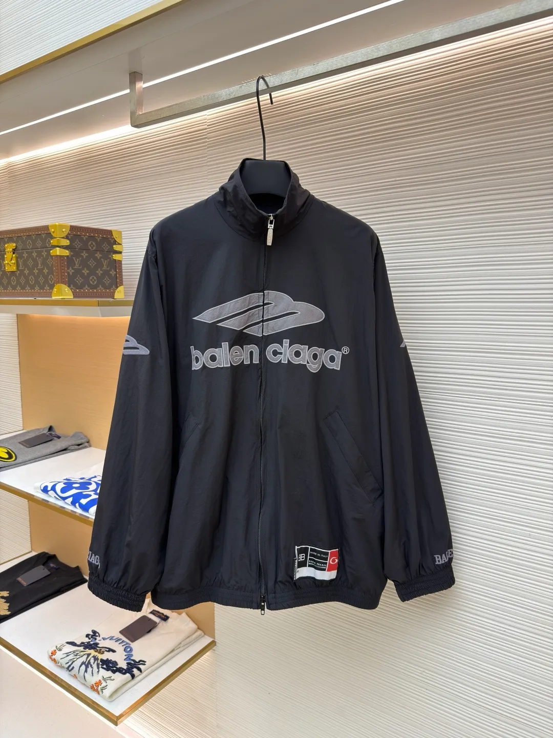 Balenciaga letter logo printed long-sleeved stand-collar jacket ●Original version: purchased and developed by 18499 ●Item number: 1682141-B45 ●Fabric: technical quick-drying fabric ●Technology: printing production ●Color: black ●Version: loose fit ●Weight: about 465 grams ●Size: XS-S-M-L ●Description: This Balenciaga black jacket is made of high-density nylon taffeta fabric. The fabric is first treated with water-repellent treatment, and a nano-scale waterproof membrane is formed on the surface. It is both windproof and lightweight. It is also pre-shrunk, making the garment less likely to shrink and deform. The brand logo and pattern on the body of the garment are 3D silicone hot stamping process. It is made of environmentally friendly silicone material with high elasticity and folding resistance. It is formed by hot pressing at 180°C high temperature and high pressure. The pattern and fabric are firmly combined, not easy to fall off and have a three-dimensional matte texture. The woven label on the side adopts computerized jacquard woven label technology, with a color fastness of above level 4, and the edges are heat-sealed to prevent stripping. The zipper is a custom-made metal matte zipper with wear-resistant electroplating treatment on the teeth. The ribbed edges of the collar and hem have built-in spandex elastic yarn. The splicing of the body is made of overlock seams. The stitches are evenly spaced and the seams are flat. The entire body is ironed and shaped by hand to perfectly present the brand's iconic oversize loose fit. The overall wiring is straight and delicate, the fabric is comfortable and soft, and the color is consistent without color difference. It can be matched with the same style to create a fashionable look and control various occasions. Customized accessories, complete with three standards, same style for men and women!