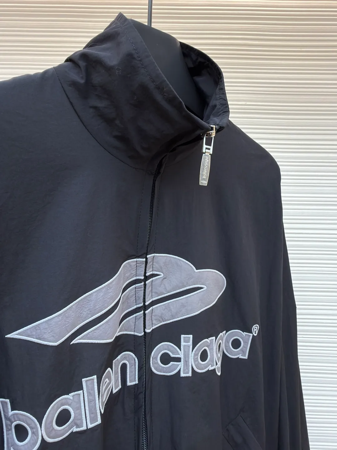Balenciaga letter logo printed long-sleeved stand-collar jacket ●Original version: purchased and developed by 18499 ●Item number: 1682141-B45 ●Fabric: technical quick-drying fabric ●Technology: printing production ●Color: black ●Version: loose fit ●Weight: about 465 grams ●Size: XS-S-M-L ●Description: This Balenciaga black jacket is made of high-density nylon taffeta fabric. The fabric is first treated with water-repellent treatment, and a nano-scale waterproof membrane is formed on the surface. It is both windproof and lightweight. It is also pre-shrunk, making the garment less likely to shrink and deform. The brand logo and pattern on the body of the garment are 3D silicone hot stamping process. It is made of environmentally friendly silicone material with high elasticity and folding resistance. It is formed by hot pressing at 180°C high temperature and high pressure. The pattern and fabric are firmly combined, not easy to fall off and have a three-dimensional matte texture. The woven label on the side adopts computerized jacquard woven label technology, with a color fastness of above level 4, and the edges are heat-sealed to prevent stripping. The zipper is a custom-made metal matte zipper with wear-resistant electroplating treatment on the teeth. The ribbed edges of the collar and hem have built-in spandex elastic yarn. The splicing of the body is made of overlock seams. The stitches are evenly spaced and the seams are flat. The entire body is ironed and shaped by hand to perfectly present the brand's iconic oversize loose fit. The overall wiring is straight and delicate, the fabric is comfortable and soft, and the color is consistent without color difference. It can be matched with the same style to create a fashionable look and control various occasions. Customized accessories, complete with three standards, same style for men and women!