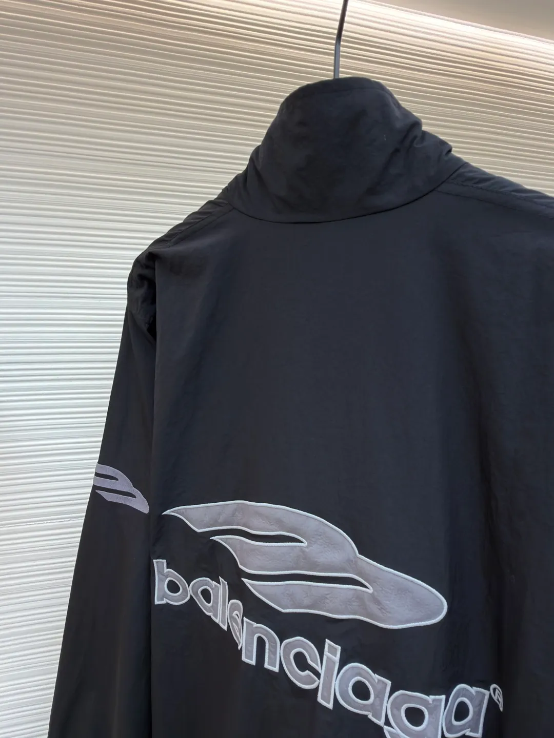 Balenciaga letter logo printed long-sleeved stand-collar jacket ●Original version: purchased and developed by 18499 ●Item number: 1682141-B45 ●Fabric: technical quick-drying fabric ●Technology: printing production ●Color: black ●Version: loose fit ●Weight: about 465 grams ●Size: XS-S-M-L ●Description: This Balenciaga black jacket is made of high-density nylon taffeta fabric. The fabric is first treated with water-repellent treatment, and a nano-scale waterproof membrane is formed on the surface. It is both windproof and lightweight. It is also pre-shrunk, making the garment less likely to shrink and deform. The brand logo and pattern on the body of the garment are 3D silicone hot stamping process. It is made of environmentally friendly silicone material with high elasticity and folding resistance. It is formed by hot pressing at 180°C high temperature and high pressure. The pattern and fabric are firmly combined, not easy to fall off and have a three-dimensional matte texture. The woven label on the side adopts computerized jacquard woven label technology, with a color fastness of above level 4, and the edges are heat-sealed to prevent stripping. The zipper is a custom-made metal matte zipper with wear-resistant electroplating treatment on the teeth. The ribbed edges of the collar and hem have built-in spandex elastic yarn. The splicing of the body is made of overlock seams. The stitches are evenly spaced and the seams are flat. The entire body is ironed and shaped by hand to perfectly present the brand's iconic oversize loose fit. The overall wiring is straight and delicate, the fabric is comfortable and soft, and the color is consistent without color difference. It can be matched with the same style to create a fashionable look and control various occasions. Customized accessories, complete with three standards, same style for men and women!