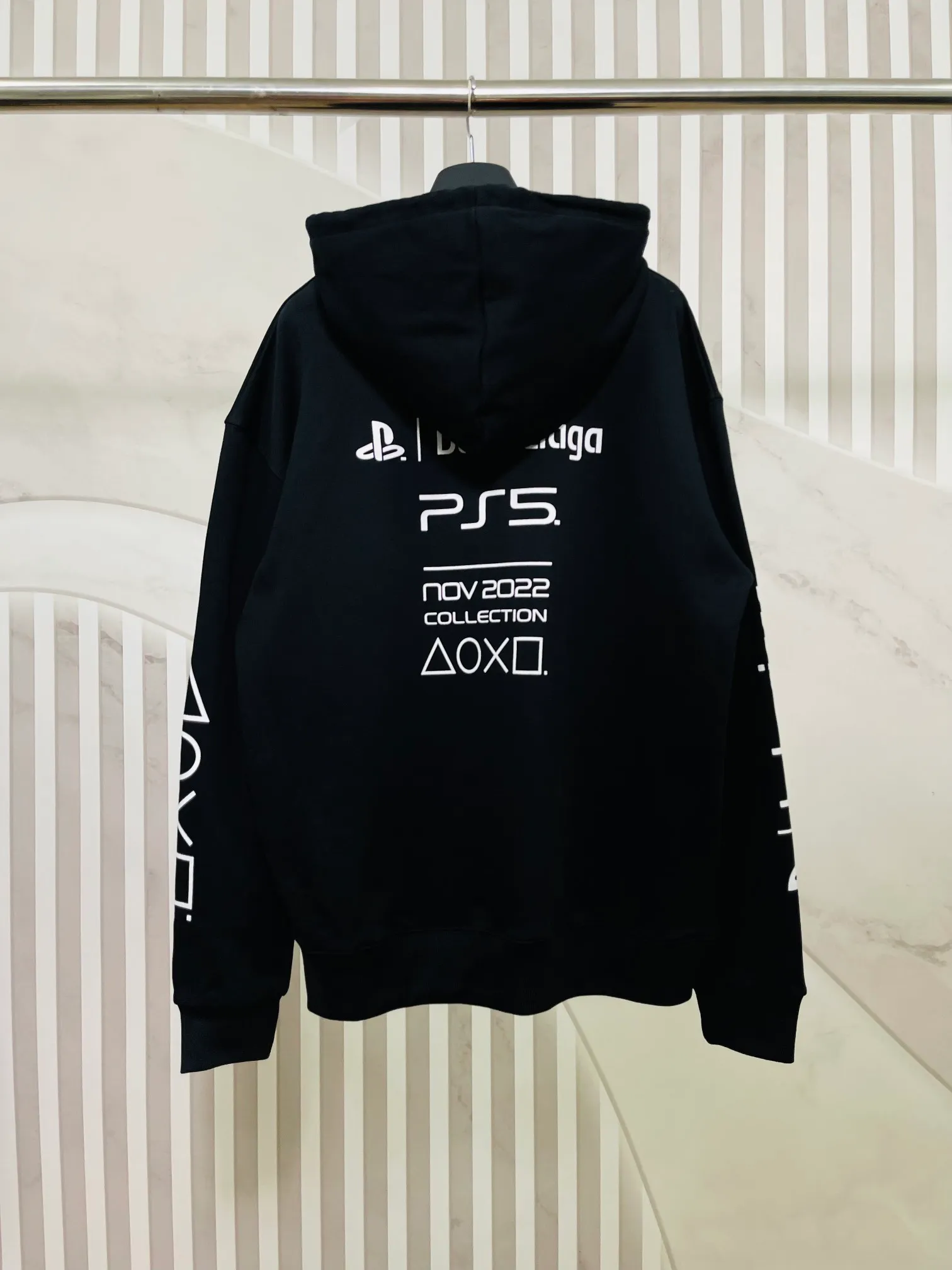 🅿️296 Real photos [Top version. Official website quality] BALENCI*GA/Paris. Classic model 22SS #BALENCI*GA / PlayStation co-branded. Ps5 letter geometric pattern printed hooded long-sleeved sweatshirt. Autumn and winter brick cabinet synchronization. The fabric is made of Paris ZP custom-woven and dyed 100% cotton double-yarn large sweater. The net weight is 460 grams. The cloth surface is clean. The cloth pattern is clear, soft and comfortable. The threads are woven and dyed with no color difference. The classic letter pattern is made of precision mesh. Imported environmentally friendly rubber paddle printing, the letters are clear. The effect is three-dimensional, restoring the brick cabinet, and the version adopts the OS loose shoulder style. Same style for men and women Coding: BL238085 Color: Black. White Size: XS S M L