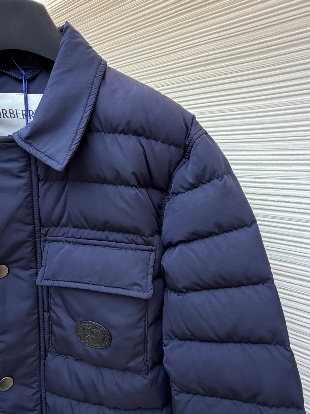 Burberry light leather label down jacket ●Original version: Purchased and developed by 6125 ●Item number: 1681879-C95 ●Fabric: white duck down fabric ●Technology: mechanical down filling ●Color: navy blue ●Version: fitted version ●Weight: about 780 grams ●Size: S-M-L-XL ●Description: High-density nylon taffeta: Made of 100D nylon fabric, density ≥230T, durable Slightly calendered (showing low-key luster), and fluorine-free waterproof coating (DWR) to ensure water repellency while maintaining breathability (refer to the slightly wrinkled texture and stiffness of the fabric in the picture) Anti-velvet gallbladder: Use high-density polyester gallbladder cloth (such as gallbladder silk spinning) above 300T to ensure that the down does not rip through velvet, and is light and thin without affecting the fluffiness. Filling 900-fill white duck down (85%-90% down content) ensures a full three-dimensional effect but not too bloated. It uses YKK brand No. 5 nylon zipper (matte dark gray/black, close to the fabric). The zipper teeth are fine-toothed and flat-toothed. The puller is simple and square. The brand logo is etched on the surface. The outside of the zipper needs to be seamed. 1.5cm wide windproof placket made of the same color fabric (double-layered, with thin cotton strips sandwiched inside to increase stiffness). The cuffs are fake two-piece design (the outer layer is folded cuffs, and the inner layer is ribbed). The outer cuffs are equipped with 2 metal buttons (diameter 12mm, the same series as the pocket snaps), with a spacing of 3cm. The buttonholes are hand-made keyholes (double-line seaming, precise aperture). They are made of first-layer calfskin (thickness 0.8-mm). The leather surface is matte aniline dyed and the edges are warped. Oil edge treatment (thickness 0.3mm, round and smooth, color consistent with leather label). The brand pattern (knight logo + text) on the surface of the leather label adopts embossing + hot stamping/silvering technology. The overall wiring is straight and delicate, the fabric is comfortable and soft, and the color is consistent without color difference. It can be matched with the same style to create a fashionable look and control various occasions. Customized accessories, complete with three labels, same style for men and women!