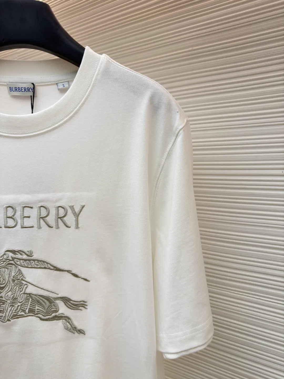 Burberry Thin Line War Horse Embroidery Round Neck Short Sleeve ●Original version: 3250 purchase and development ●Item number: 1681453-X90 ●Fabric: pure cotton fabric ●Technology: embroidery production ●Color: white ●Version: fitted version ●Weight: about 300 grams ●Size: S-M-L-XL ●Description: This T-shirt is made of high-quality pure cotton fabric, which is skin-friendly and breathable. Black and off-white tones are classic and versatile. The brand knight logo on the front adopts precision embroidery technology. The silk thread is rich in color, the stitching is delicate and three-dimensional, and the pattern is rich in layers, highlighting the high brand recognition. The round neck structure is processed by overlocking technology, and the neckline fits the neck and is not easily deformed. The body of the garment is sewn using industrial-grade flat stitching technology. The stitches are smooth and even, and the stitches at the hem and cuffs are fine and firm. From the selection of pure cotton fabrics to the control of embroidery details, every process reflects Burberry's pursuit of craft precision and classic style. It not only retains the daily practicality of the T-shirt, but also demonstrates the brand's light luxury recognition through exquisite embroidery. It is a fusion of casual style and exquisite craftsmanship. The overall wiring is straight and delicate, the fabric is comfortable and soft, and the color is consistent without color difference. It can be matched with the same style to create a fashionable look and control various occasions. Customized accessories, complete with three standards, same style for men and women!