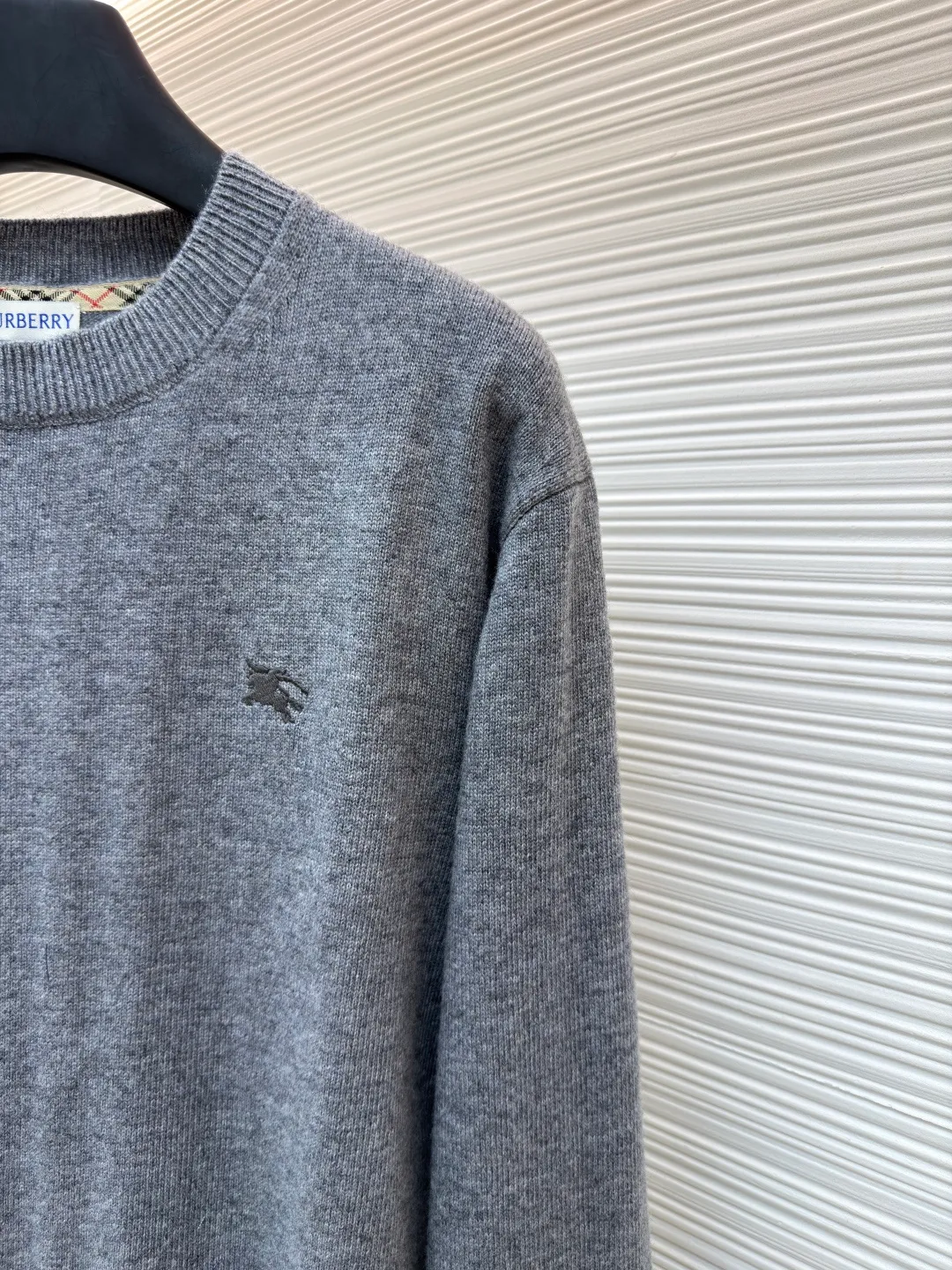 Burberry embroidered crew neck sweater ●Original version: Purchased and developed by 3631 ●Item number: 1681779-B25 ●Fabric: wool blended fabric ●Technology: Knitted production ●Color: gray ●Version: Fitted version ●Weight: about 455 grams ●Size: S-M-L-XL ●Description: Cashmere is the main material that dominates the feel, warmth and lightness of the fabric, while providing an unparalleled wearing experience. A small amount of polyamide and Lycra are added to enhance the overall durability and pilling resistance. An invisible support network is woven into the soft cashmere, and it also has a certain amount of elasticity to better fit the curves of the human body and allow it to be retracted and retracted freely. The ribbed decorative parts of the collar and cuffs are made of blended fabrics of the same proportion, which further enhances the texture and wearing experience. Due to the characteristics of the sweater fabric, it is stretched just right when stretching the frame, and then a hot-melt liner is used under the wool fabric piece to provide it with a certain temporary stable support to prevent it from shrinking after removal, causing pattern distortion, wrinkles and stitch dents. The high-precision calculation program system of the computer embroidery machine controls the movement of the embroidery frame in the X/Y direction, while the needle shuttles up and down, embroidering according to the set path, automatically completing thread trimming, thread jumping and other actions to form a stitch track, automatically adjusting the upper and lower thread tension to ensure that the stitches are smooth and free of floating threads, forming a war horse pattern with an error of ±0.1mm. Add detergent and preliminarily rinse the bulk goods at a water temperature of about 35 degrees to remove impurities during the production process, and then use protease to gently digest the hairiness on the surface to reduce the tendency of pilling from the root, improve the hand feel, retain softness, and eliminate irritation. Finally, after dehydration and drying, the dimensional and shape stability is improved. The overall wiring is straight and delicate, the fabric is comfortable and soft, and the color is consistent without color difference. It can be matched with the same style to create a fashionable look and control various occasions. Customized accessories, complete with three standards, same style for men and women!