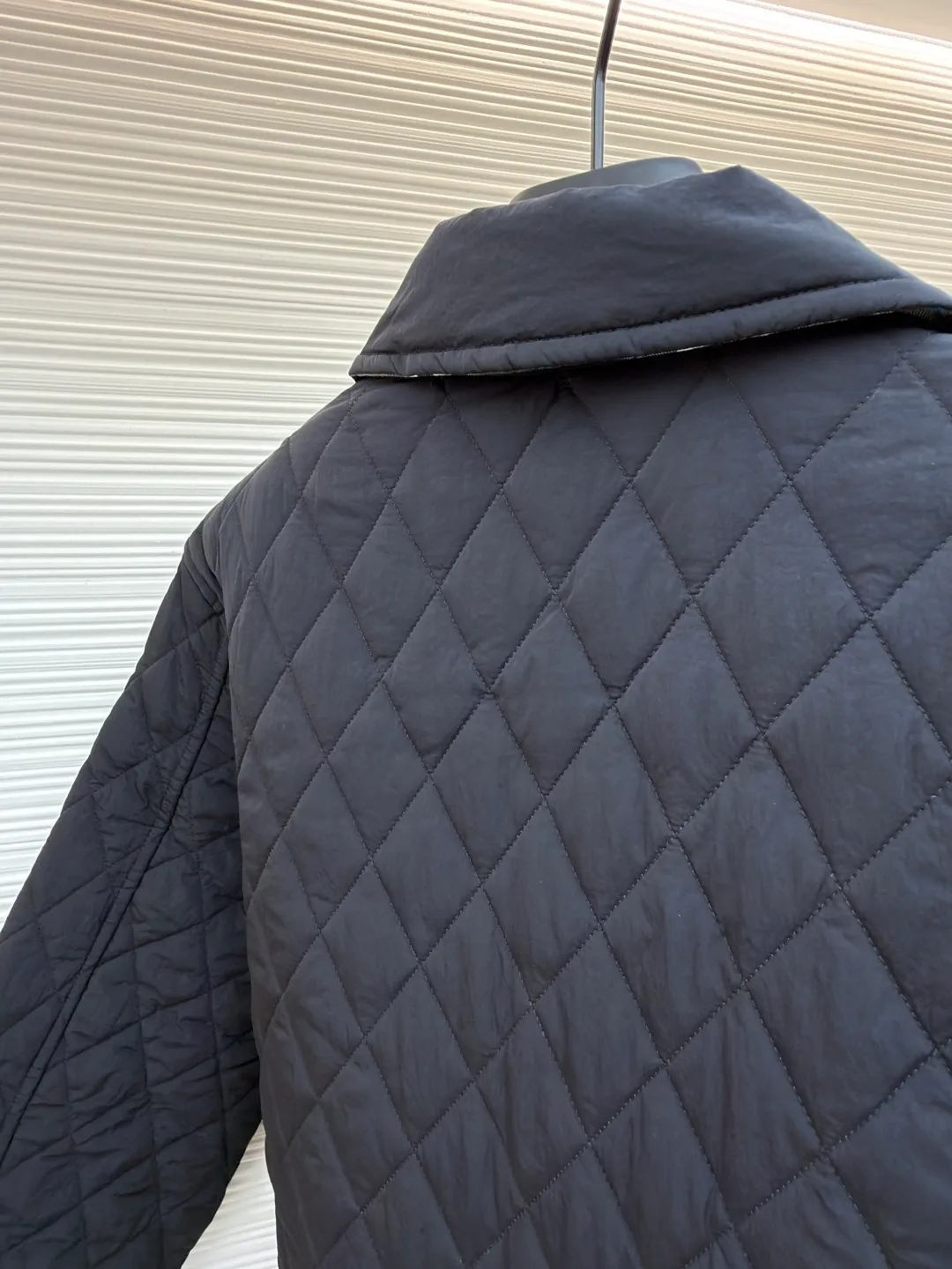 Burberry Reversible Small Collar Quilted Cotton Jacket ●Item No.: 1681636-B90 ●Material: 100% cotton ●Technology: Made on positioning cutting machine ●Color: Black ●Version: Fitted version ●Weight: about 590 grams ●Size: S-M-L-XL-XXL ●Description: This piece of clothing uses diamond quilting technology, and each frame is precisely sewn, which not only makes the overall shape more three-dimensional, but also effectively fixes the filling cotton to ensure warmth and durability.  The front features a classic lapel design and a single-breasted placket, making it easy to open and close and neatly styled. The large pockets on both sides are both practical and enhance the overall sense of hierarchy. The interior is filled with high-quality cotton, which is soft to the touch and warm. The diamond quilting design continues on the back, making the overall style unified. The cuffs and hem are carefully hemmed to reduce friction and wear and extend service life. Looking at the details, the fabric has been treated with water-repellent treatment, and minor water stains can be easily wiped away, making it suitable for various occasions. The overall shape is loose, not flattering on your figure, and comfortable to wear. Whether it is daily commuting or leisure travel, it is a good choice. The overall wiring is straight and delicate, the fabric is comfortable and soft, and the color is consistent without color difference. It can be matched with the same style to create a fashionable look and control various occasions. Customized accessories, complete with three standards, same style for men and women!