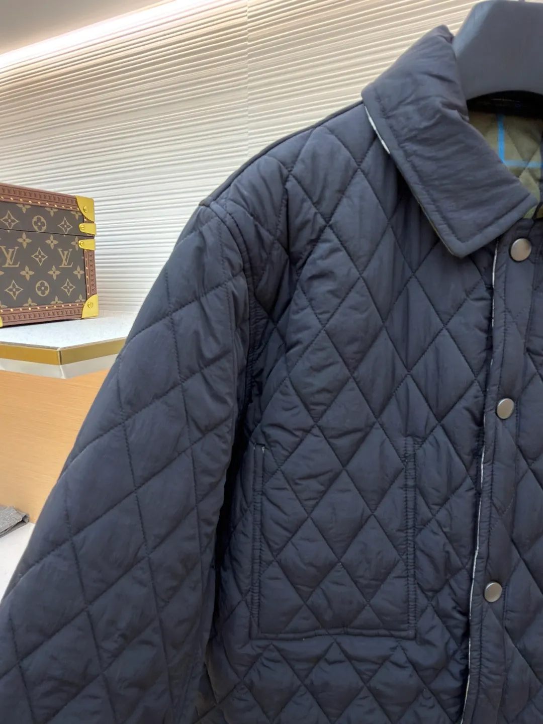 Burberry Reversible Small Collar Quilted Cotton Jacket ●Item No.: 1681636-B90 ●Material: 100% cotton ●Technology: Made on positioning cutting machine ●Color: Black ●Version: Fitted version ●Weight: about 590 grams ●Size: S-M-L-XL-XXL ●Description: This piece of clothing uses diamond quilting technology, and each frame is precisely sewn, which not only makes the overall shape more three-dimensional, but also effectively fixes the filling cotton to ensure warmth and durability.  The front features a classic lapel design and a single-breasted placket, making it easy to open and close and neatly styled. The large pockets on both sides are both practical and enhance the overall sense of hierarchy. The interior is filled with high-quality cotton, which is soft to the touch and warm. The diamond quilting design continues on the back, making the overall style unified. The cuffs and hem are carefully hemmed to reduce friction and wear and extend service life. Looking at the details, the fabric has been treated with water-repellent treatment, and minor water stains can be easily wiped away, making it suitable for various occasions. The overall shape is loose, not flattering on your figure, and comfortable to wear. Whether it is daily commuting or leisure travel, it is a good choice. The overall wiring is straight and delicate, the fabric is comfortable and soft, and the color is consistent without color difference. It can be matched with the same style to create a fashionable look and control various occasions. Customized accessories, complete with three standards, same style for men and women!