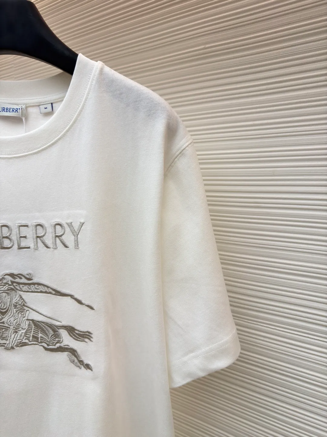 Burberry Thin Line War Horse Embroidery Round Neck Short Sleeve ●Original version: Purchased and developed for 3250 ●Item number: 1681453-X85 ●Fabric: pure cotton fabric ●Technology: embroidery production ●Color: black ●Version: fitted version ●Weight: about 275 grams ●Size: S-M-L-XL ●Description: This T-shirt is made of high-quality pure cotton fabric, which is skin-friendly and breathable. The black and off-white tones are classic and versatile. The brand knight logo on the front adopts precision embroidery technology. The silk thread is rich in color, the stitching is delicate and three-dimensional, and the pattern is rich in layers, highlighting the high brand recognition. The round neck structure is processed by overlocking technology, and the neckline fits the neck and is not easily deformed. The body of the garment is sewn using industrial-grade flat stitching technology. The stitches are smooth and even, and the stitches at the hem and cuffs are fine and firm. From the selection of pure cotton fabrics to the control of embroidery details, every process reflects Burberry's pursuit of craft precision and classic style. It not only retains the daily practicality of the T-shirt, but also demonstrates the brand's light luxury recognition through exquisite embroidery. It is a fusion of casual style and exquisite craftsmanship. The overall wiring is straight and delicate, the fabric is comfortable and soft, and the color is consistent without color difference. It can be matched with the same style to create a fashionable look and control various occasions. Customized accessories, complete with three standards, same style for men and women!