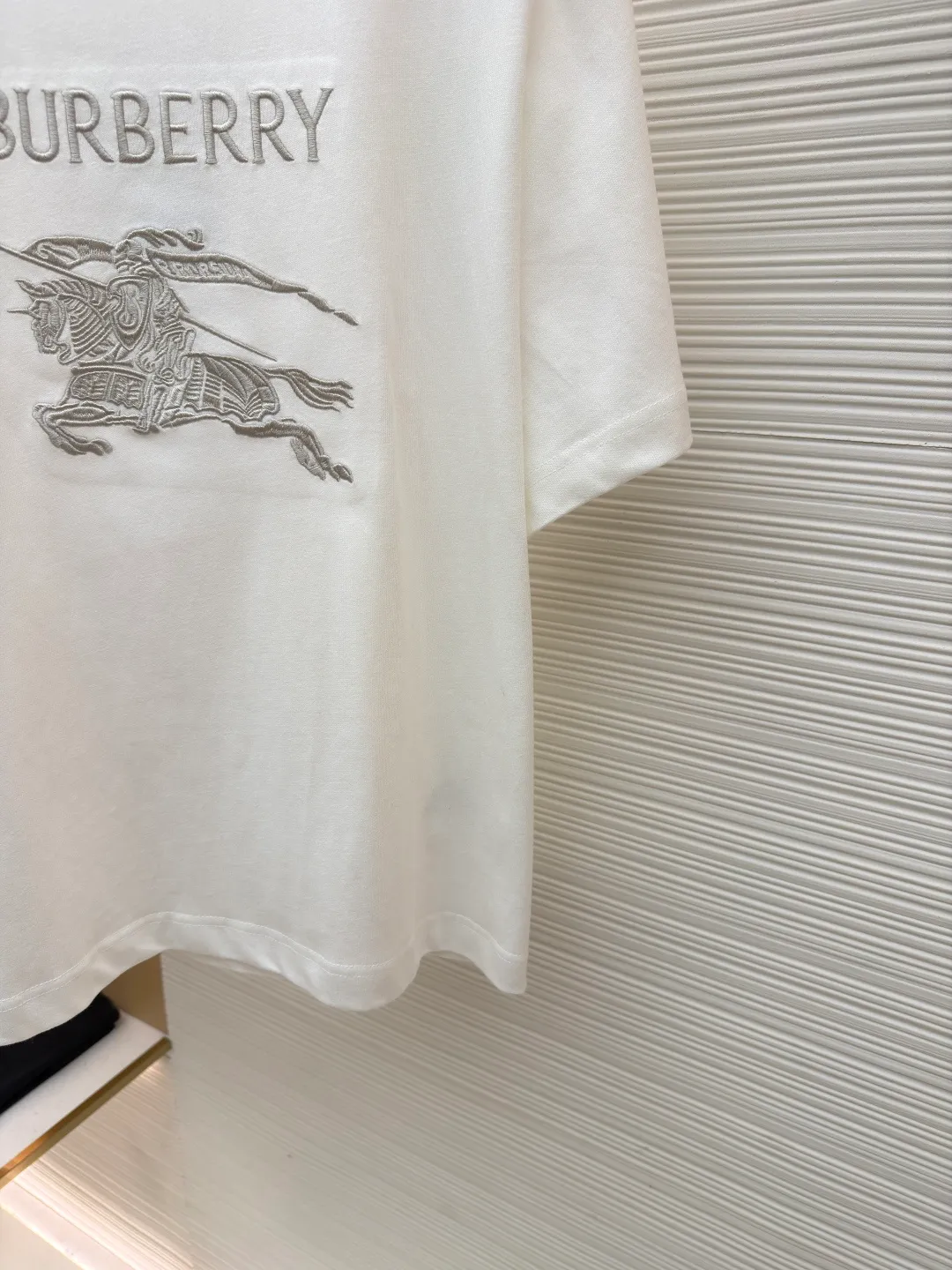 Burberry Thin Line War Horse Embroidery Round Neck Short Sleeve ●Original version: Purchased and developed for 3250 ●Item number: 1681453-X85 ●Fabric: pure cotton fabric ●Technology: embroidery production ●Color: black ●Version: fitted version ●Weight: about 275 grams ●Size: S-M-L-XL ●Description: This T-shirt is made of high-quality pure cotton fabric, which is skin-friendly and breathable. The black and off-white tones are classic and versatile. The brand knight logo on the front adopts precision embroidery technology. The silk thread is rich in color, the stitching is delicate and three-dimensional, and the pattern is rich in layers, highlighting the high brand recognition. The round neck structure is processed by overlocking technology, and the neckline fits the neck and is not easily deformed. The body of the garment is sewn using industrial-grade flat stitching technology. The stitches are smooth and even, and the stitches at the hem and cuffs are fine and firm. From the selection of pure cotton fabrics to the control of embroidery details, every process reflects Burberry's pursuit of craft precision and classic style. It not only retains the daily practicality of the T-shirt, but also demonstrates the brand's light luxury recognition through exquisite embroidery. It is a fusion of casual style and exquisite craftsmanship. The overall wiring is straight and delicate, the fabric is comfortable and soft, and the color is consistent without color difference. It can be matched with the same style to create a fashionable look and control various occasions. Customized accessories, complete with three standards, same style for men and women!
