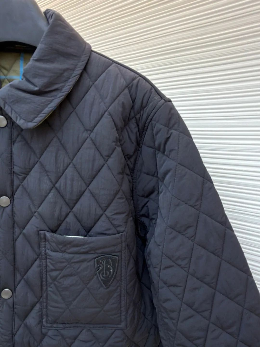 Burberry Reversible Small Collar Quilted Cotton Jacket ●Item No.: 1681636-B90 ●Material: 100% cotton ●Technology: Made on positioning cutting machine ●Color: Black ●Version: Fitted version ●Weight: about 590 grams ●Size: S-M-L-XL-XXL ●Description: This piece of clothing uses diamond quilting technology, and each frame is precisely sewn, which not only makes the overall shape more three-dimensional, but also effectively fixes the filling cotton to ensure warmth and durability.  The front features a classic lapel design and a single-breasted placket, making it easy to open and close and neatly styled. The large pockets on both sides are both practical and enhance the overall sense of hierarchy. The interior is filled with high-quality cotton, which is soft to the touch and warm. The diamond quilting design continues on the back, making the overall style unified. The cuffs and hem are carefully hemmed to reduce friction and wear and extend service life. Looking at the details, the fabric has been treated with water-repellent treatment, and minor water stains can be easily wiped away, making it suitable for various occasions. The overall shape is loose, not flattering on your figure, and comfortable to wear. Whether it is daily commuting or leisure travel, it is a good choice. The overall wiring is straight and delicate, the fabric is comfortable and soft, and the color is consistent without color difference. It can be matched with the same style to create a fashionable look and control various occasions. Customized accessories, complete with three standards, same style for men and women!