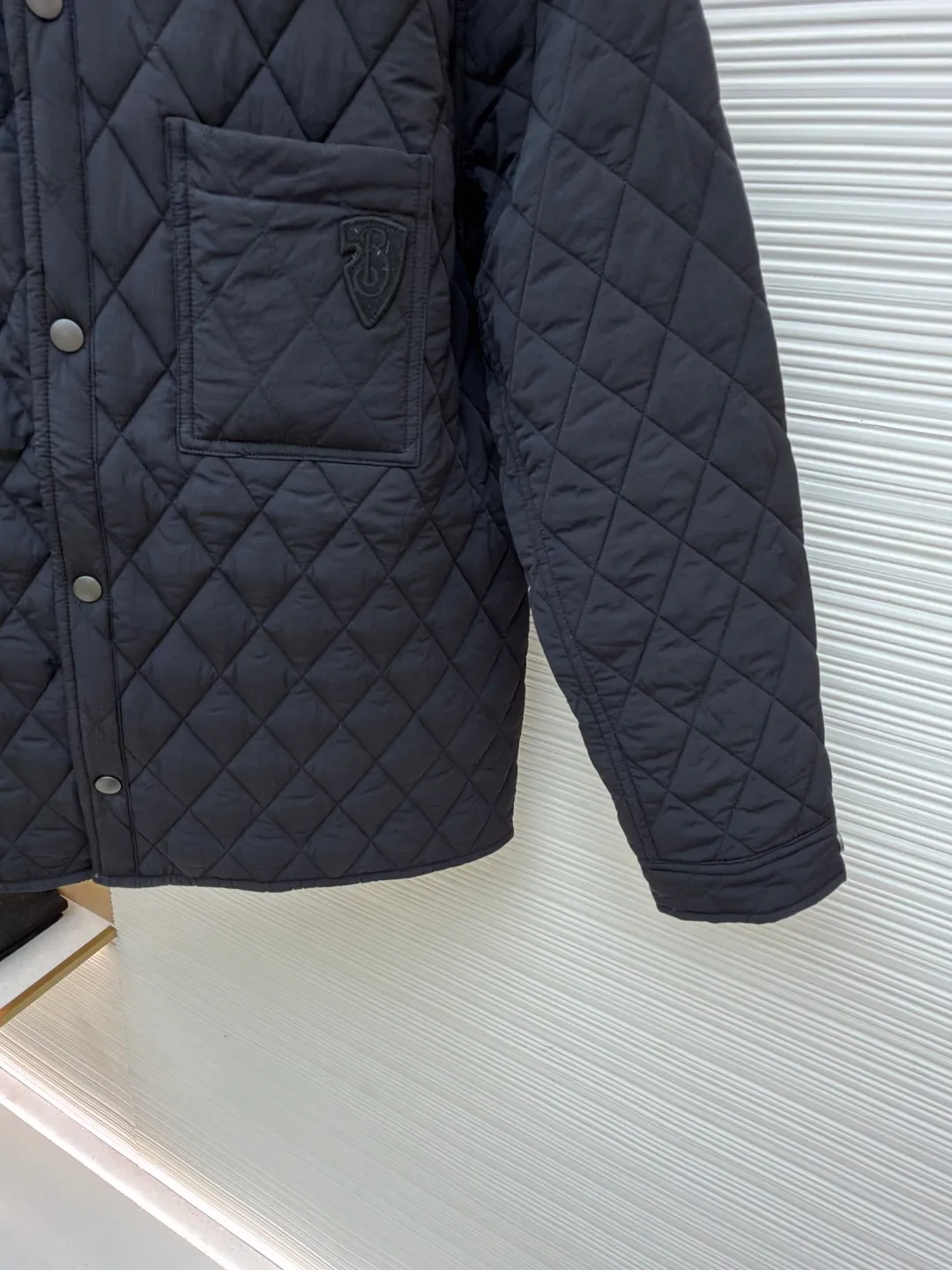 Burberry Reversible Small Collar Quilted Cotton Jacket ●Item No.: 1681636-B90 ●Material: 100% cotton ●Technology: Made on positioning cutting machine ●Color: Black ●Version: Fitted version ●Weight: about 590 grams ●Size: S-M-L-XL-XXL ●Description: This piece of clothing uses diamond quilting technology, and each frame is precisely sewn, which not only makes the overall shape more three-dimensional, but also effectively fixes the filling cotton to ensure warmth and durability.  The front features a classic lapel design and a single-breasted placket, making it easy to open and close and neatly styled. The large pockets on both sides are both practical and enhance the overall sense of hierarchy. The interior is filled with high-quality cotton, which is soft to the touch and warm. The diamond quilting design continues on the back, making the overall style unified. The cuffs and hem are carefully hemmed to reduce friction and wear and extend service life. Looking at the details, the fabric has been treated with water-repellent treatment, and minor water stains can be easily wiped away, making it suitable for various occasions. The overall shape is loose, not flattering on your figure, and comfortable to wear. Whether it is daily commuting or leisure travel, it is a good choice. The overall wiring is straight and delicate, the fabric is comfortable and soft, and the color is consistent without color difference. It can be matched with the same style to create a fashionable look and control various occasions. Customized accessories, complete with three standards, same style for men and women!