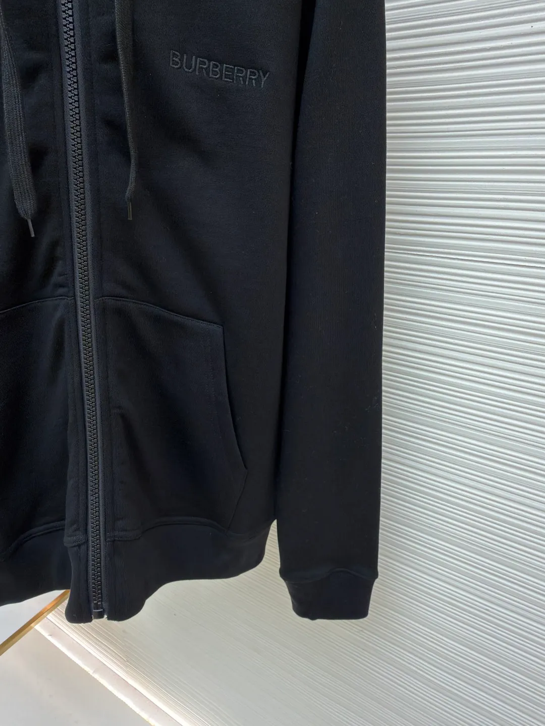 Burberry classic embroidered LOGO hooded long-sleeved sweatshirt ●Original version: purchased and developed by 3108 ●Item number: 1682381-B15 ●Material: combed cotton fabric ●Technology: embroidery production ●Color: black ●Version: fitted version ●Weight: about 905 grams ●Size: S-M-L ●Description: This Burberry classic embroidered LOGO hooded sweatshirt is made of 380g combed cotton terry fabric, which has been treated with an enzyme washing process. The fabric is soft and skin-friendly and has good hygroscopicity. It has also been pre-shrunk and anti-pilling, making it less likely to deform and fluff after washing. The inside of the hood is spliced ​​with the brand's classic plaid fabric, using manual alignment and splicing technology. The alignment error of the plaid pattern does not exceed 0.3cm. The drawstring is a custom-made pure cotton rope strap, and the metal rope head is polished for a refined texture. The front is equipped with a YKK customized metal zipper, which is smooth, easy to pull and anti-oxidation. The brand LOGO on the chest adopts imported flat embroidery technology. The embroidery thread is made of high color fastness yarn. The stitches are fine and even, and the pattern is three-dimensional and clear. The kangaroo pocket is an integrated tailoring design with double-needle seaming reinforcement at the edges. The high-elastic rib fabric on the cuffs and hem is custom-woven and dyed, so it will not loosen after long-term wear. The overall seams are overlocked and the details combine the brand's classic elements with exquisite clothing craftsmanship. The fit is loose and comfortable, suitable for daily wear. The overall wiring is straight and delicate, the fabric is comfortable and soft, and the color is consistent without color difference. It can be matched with the same style to create a fashionable look and control various occasions. Customized accessories, complete with three standards, same style for men and women!