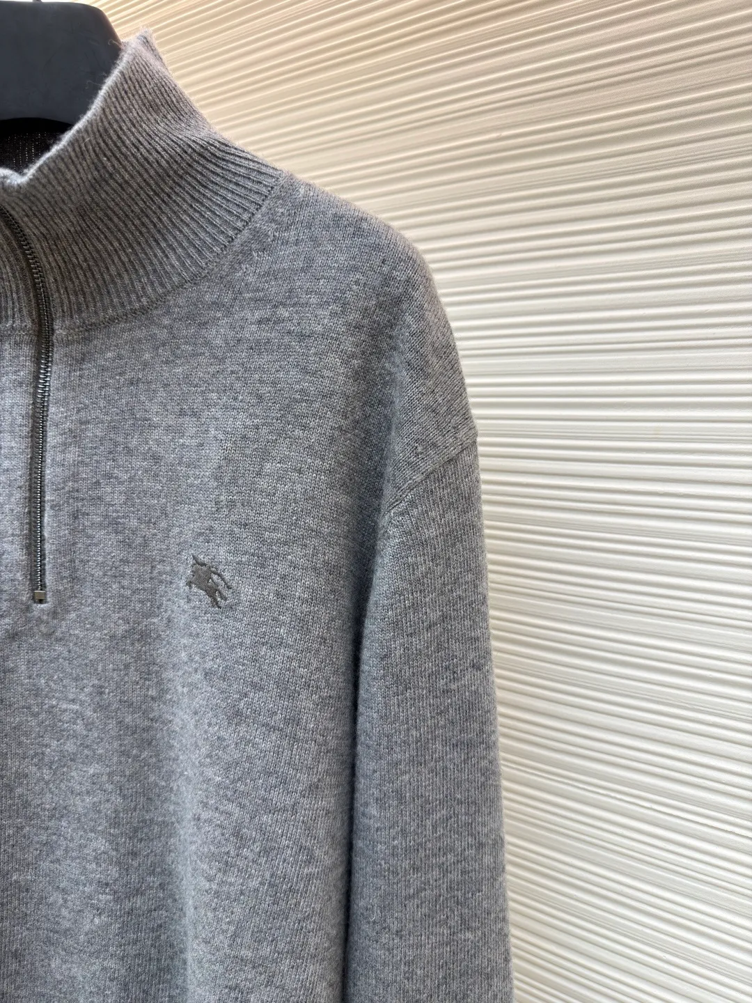 Burberry embroidered half-zip turtleneck sweater ●Original version: Purchased and developed by 4722 ●Item number: 1681784-B25 ●Fabric: wool blended fabric ●Technology: knitted production ●Color: gray ●Version: fitted version ●Weight: about 550 grams ●Size: S-M-L-XL ●Description: cashmere is used as the main body to dominate the feel, warmth and lightness of the fabric, while providing an unparalleled wearing experience. A small amount of polyamide and Lycra are added to enhance the overall durability and pilling resistance. An invisible support network is woven into the soft cashmere, and it also has a certain amount of elasticity to better fit the curves of the human body and allow it to be retracted and retracted freely. Due to the characteristics of the sweater fabric, it is stretched just right when stretching the frame, and then a hot-melt liner is used under the wool fabric piece to provide it with a certain temporary stable support to prevent it from shrinking after removal, causing pattern distortion, wrinkles and stitch dents. The high-precision calculation program system of the computer embroidery machine controls the movement of the embroidery frame in the X/Y direction, while the needle shuttles up and down, embroidering according to the set path, automatically completing thread trimming, thread jumping and other actions to form a stitch track, automatically adjusting the upper and lower thread tension to ensure that the stitches are smooth and free of floating threads, forming a war horse pattern with an error of ±0.1mm. Add detergent and preliminarily rinse the bulk goods at a water temperature of about 35 degrees to remove impurities during the production process, and then use protease to gently digest the hairiness on the surface to reduce the tendency of pilling from the root, improve the hand feel, retain softness, and eliminate irritation. After the final dehydration and drying process, the overall wiring is straight and delicate, the fabric is comfortable and soft, and the color is consistent without color difference. It can be matched with the same style to create a fashionable look and control various occasions. Customized accessories, complete with three standards, same style for men and women!