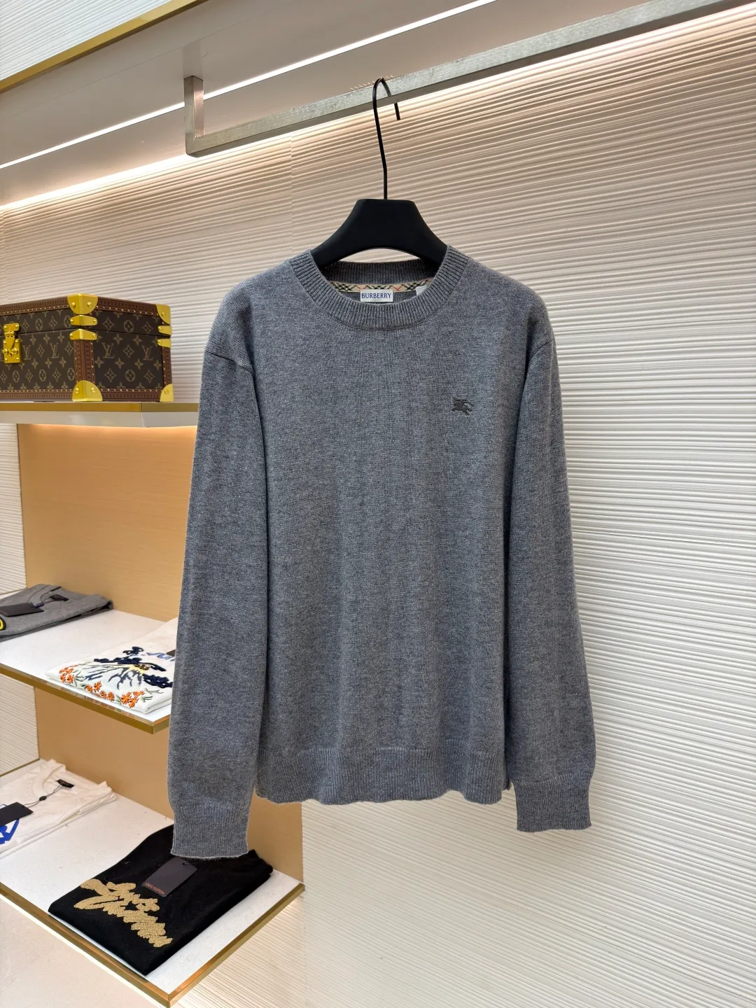 Burberry embroidered crew neck sweater ●Original version: Purchased and developed by 3631 ●Item number: 1681779-B25 ●Fabric: wool blended fabric ●Technology: Knitted production ●Color: gray ●Version: Fitted version ●Weight: about 455 grams ●Size: S-M-L-XL ●Description: Cashmere is the main material that dominates the feel, warmth and lightness of the fabric, while providing an unparalleled wearing experience. A small amount of polyamide and Lycra are added to enhance the overall durability and pilling resistance. An invisible support network is woven into the soft cashmere, and it also has a certain amount of elasticity to better fit the curves of the human body and allow it to be retracted and retracted freely. The ribbed decorative parts of the collar and cuffs are made of blended fabrics of the same proportion, which further enhances the texture and wearing experience. Due to the characteristics of the sweater fabric, it is stretched just right when stretching the frame, and then a hot-melt liner is used under the wool fabric piece to provide it with a certain temporary stable support to prevent it from shrinking after removal, causing pattern distortion, wrinkles and stitch dents. The high-precision calculation program system of the computer embroidery machine controls the movement of the embroidery frame in the X/Y direction, while the needle shuttles up and down, embroidering according to the set path, automatically completing thread trimming, thread jumping and other actions to form a stitch track, automatically adjusting the upper and lower thread tension to ensure that the stitches are smooth and free of floating threads, forming a war horse pattern with an error of ±0.1mm. Add detergent and preliminarily rinse the bulk goods at a water temperature of about 35 degrees to remove impurities during the production process, and then use protease to gently digest the hairiness on the surface to reduce the tendency of pilling from the root, improve the hand feel, retain softness, and eliminate irritation. Finally, after dehydration and drying, the dimensional and shape stability is improved. The overall wiring is straight and delicate, the fabric is comfortable and soft, and the color is consistent without color difference. It can be matched with the same style to create a fashionable look and control various occasions. Customized accessories, complete with three standards, same style for men and women!