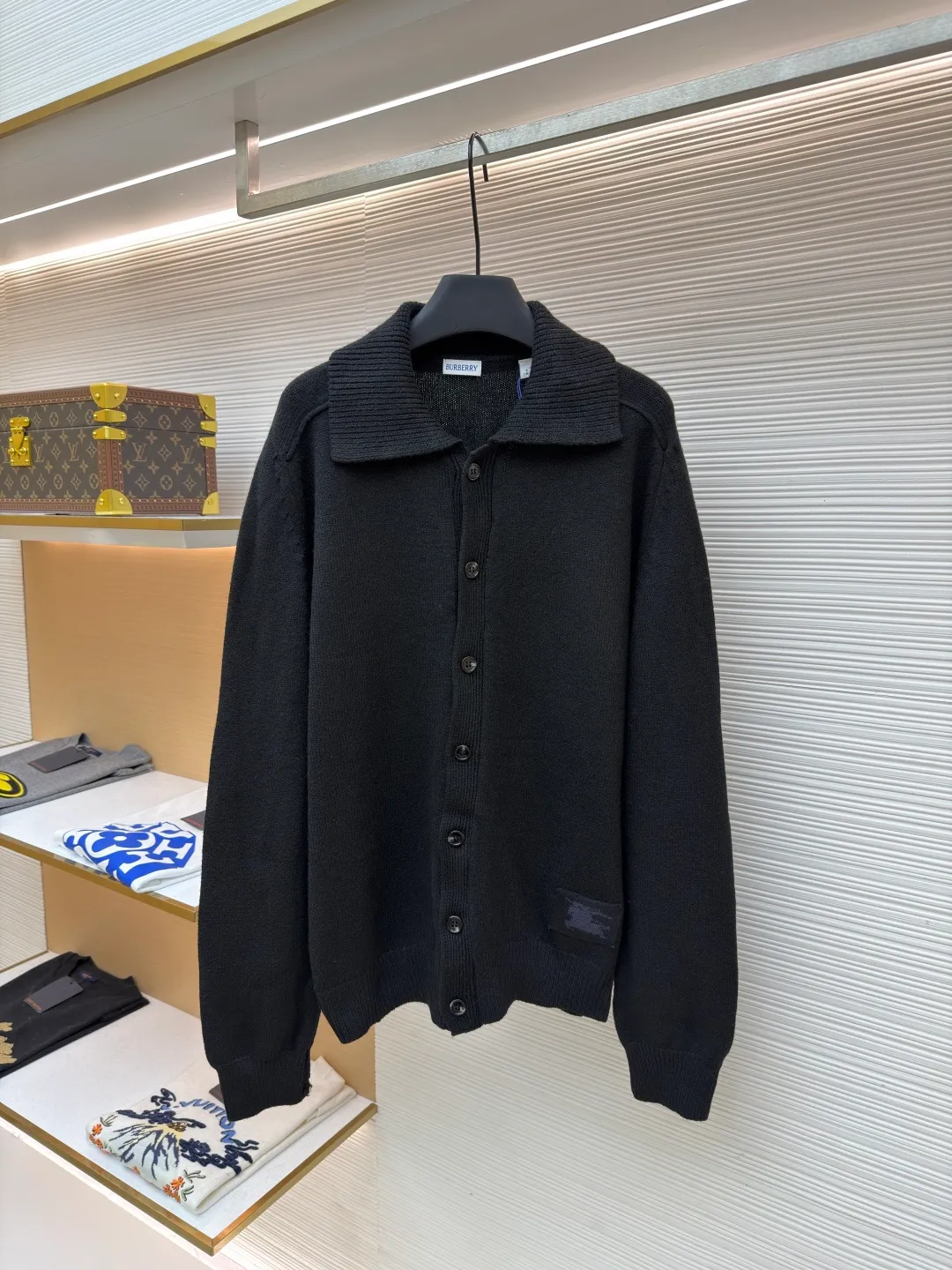 Burberry lapel rib knitted cashmere sweater ●Original version: purchased and developed by 11575 ●Item number: 1682226-B15 ●Fabric: wool blended fabric ●Technology: knitted ●Color: black ●Version: fitted version ●Weight: about 600 grams ●Size: S-M-L-XL ●Description: This black knitted cardigan is knitted with high-count worsted wool yarn. The main body is built using four-flat stitch technology, which gives the fabric good elasticity and shapeability, while forming a fine and tight texture. The ribbed lapel weaving process is used at the neckline, and a combination of different needle types is used to create a crisp collar profile. The rib structure can be freely expanded and contracted according to the wearing status to fit the neck line. The placket adopts inlaid buttonhole technology and is matched with matte resin buttons of the same color. The buttons and the body are fixed by hand-stitching, which is strong and beautiful. The brand logo patch on the lower side of the body is processed by a hot-pressing bonding process and fits seamlessly with the knitted fabric. The overall cut is a slightly loose shoulder-drop version, combined with three-dimensional darting technology, which ensures wearing comfort while creating clean lines. Every knitting node is manually inspected to ensure the uniformity and integrity of the knitted texture. The overall wiring is straight and delicate, the fabric is comfortable and soft, and the color is consistent without color difference. It can be matched with the same style to create a fashionable look and control various occasions. Customized accessories, complete with three standards, same style for men and women!