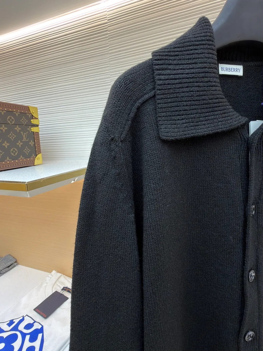 Burberry lapel rib knitted cashmere sweater ●Original version: purchased and developed by 11575 ●Item number: 1682226-B15 ●Fabric: wool blended fabric ●Technology: knitted ●Color: black ●Version: fitted version ●Weight: about 600 grams ●Size: S-M-L-XL ●Description: This black knitted cardigan is knitted with high-count worsted wool yarn. The main body is built using four-flat stitch technology, which gives the fabric good elasticity and shapeability, while forming a fine and tight texture. The ribbed lapel weaving process is used at the neckline, and a combination of different needle types is used to create a crisp collar profile. The rib structure can be freely expanded and contracted according to the wearing status to fit the neck line. The placket adopts inlaid buttonhole technology and is matched with matte resin buttons of the same color. The buttons and the body are fixed by hand-stitching, which is strong and beautiful. The brand logo patch on the lower side of the body is processed by a hot-pressing bonding process and fits seamlessly with the knitted fabric. The overall cut is a slightly loose shoulder-drop version, combined with three-dimensional darting technology, which ensures wearing comfort while creating clean lines. Every knitting node is manually inspected to ensure the uniformity and integrity of the knitted texture. The overall wiring is straight and delicate, the fabric is comfortable and soft, and the color is consistent without color difference. It can be matched with the same style to create a fashionable look and control various occasions. Customized accessories, complete with three standards, same style for men and women!