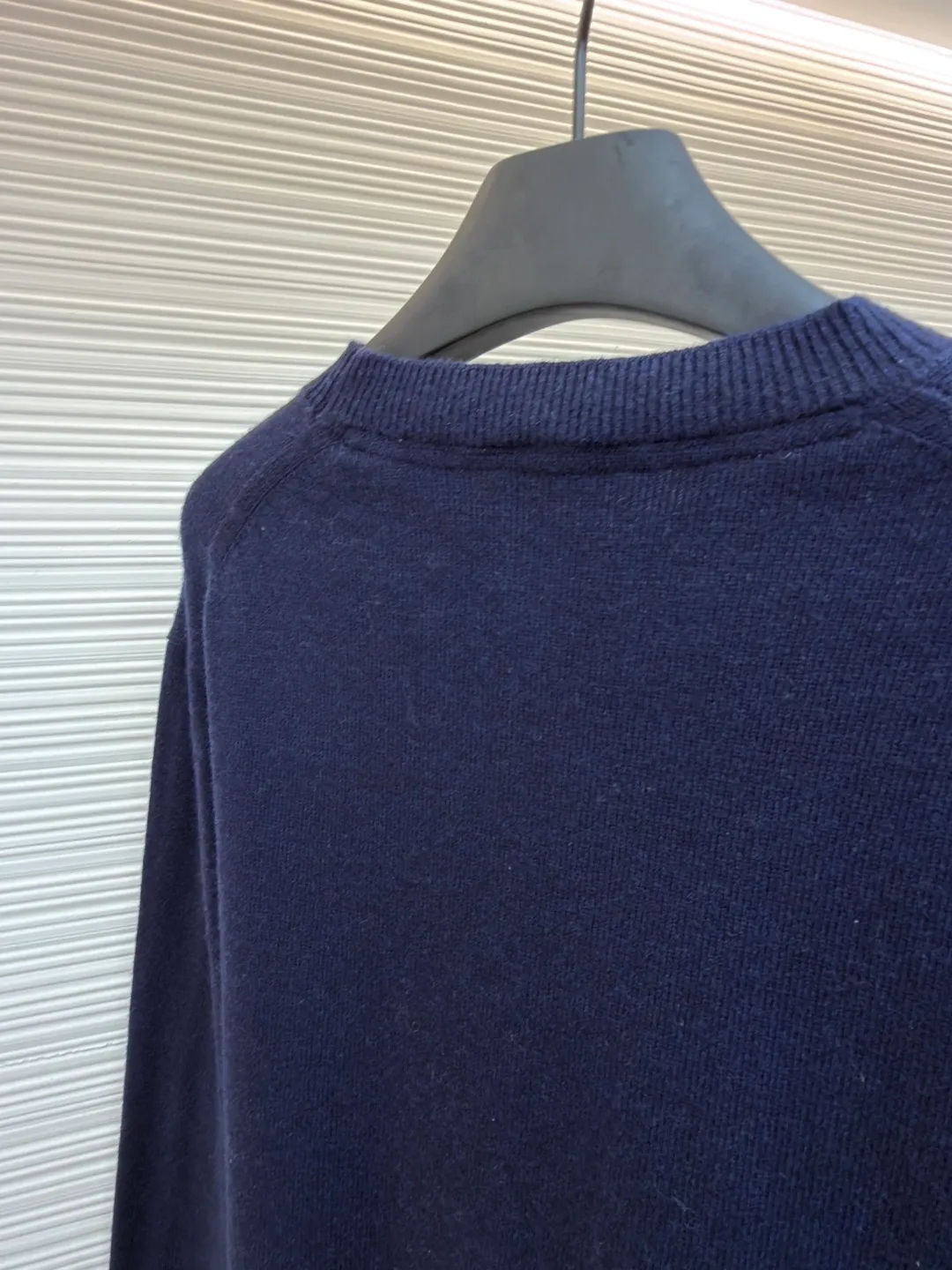 Burberry embroidered crew neck sweater ●Original version: Purchased and developed for 1499 ●Item number: 1681780-B25 ●Fabric: wool blended fabric ●Technology: knitted ●Color: navy ●Version: Fitted version ●Weight: about 465 grams ●Size: S-M-L-XL ●Description: Cashmere is used as the main body to dominate the feel, warmth and lightness of the fabric, while providing an unparalleled wearing experience. A small amount of polyamide and Lycra are added to enhance the overall durability and pilling resistance. An invisible support network is woven into the soft cashmere, and it also has a certain amount of elasticity to better fit the curves of the human body and allow it to be retracted and retracted freely. The ribbed decorative parts of the collar and cuffs are made of blended fabrics of the same proportion, which further enhances the texture and wearing experience. Due to the characteristics of the sweater fabric, it is stretched just right when stretching the frame, and then a hot-melt liner is used under the wool fabric piece to provide it with a certain temporary stable support to prevent it from shrinking after removal, causing pattern distortion, wrinkles and stitch dents. The high-precision calculation program system of the computer embroidery machine controls the movement of the embroidery frame in the X/Y direction, while the needle shuttles up and down, embroidering according to the set path, automatically completing thread trimming, thread jumping and other actions to form a stitch track, automatically adjusting the upper and lower thread tension to ensure that the stitches are smooth and free of floating threads, forming a war horse pattern with an error of ±0.1mm. Add detergent and preliminarily rinse the bulk goods at a water temperature of about 35 degrees to remove impurities during the production process, and then use protease to gently digest the hairiness on the surface to reduce the tendency of pilling from the root, improve the hand feel, retain softness, and eliminate irritation. Finally, after dehydration and drying, the dimensional and shape stability is improved. The overall wiring is straight and delicate, the fabric is comfortable and soft, and the color is consistent without color difference. It can be matched with the same style to create a fashionable look and control various occasions. Customized accessories, complete with three standards, same style for men and women!