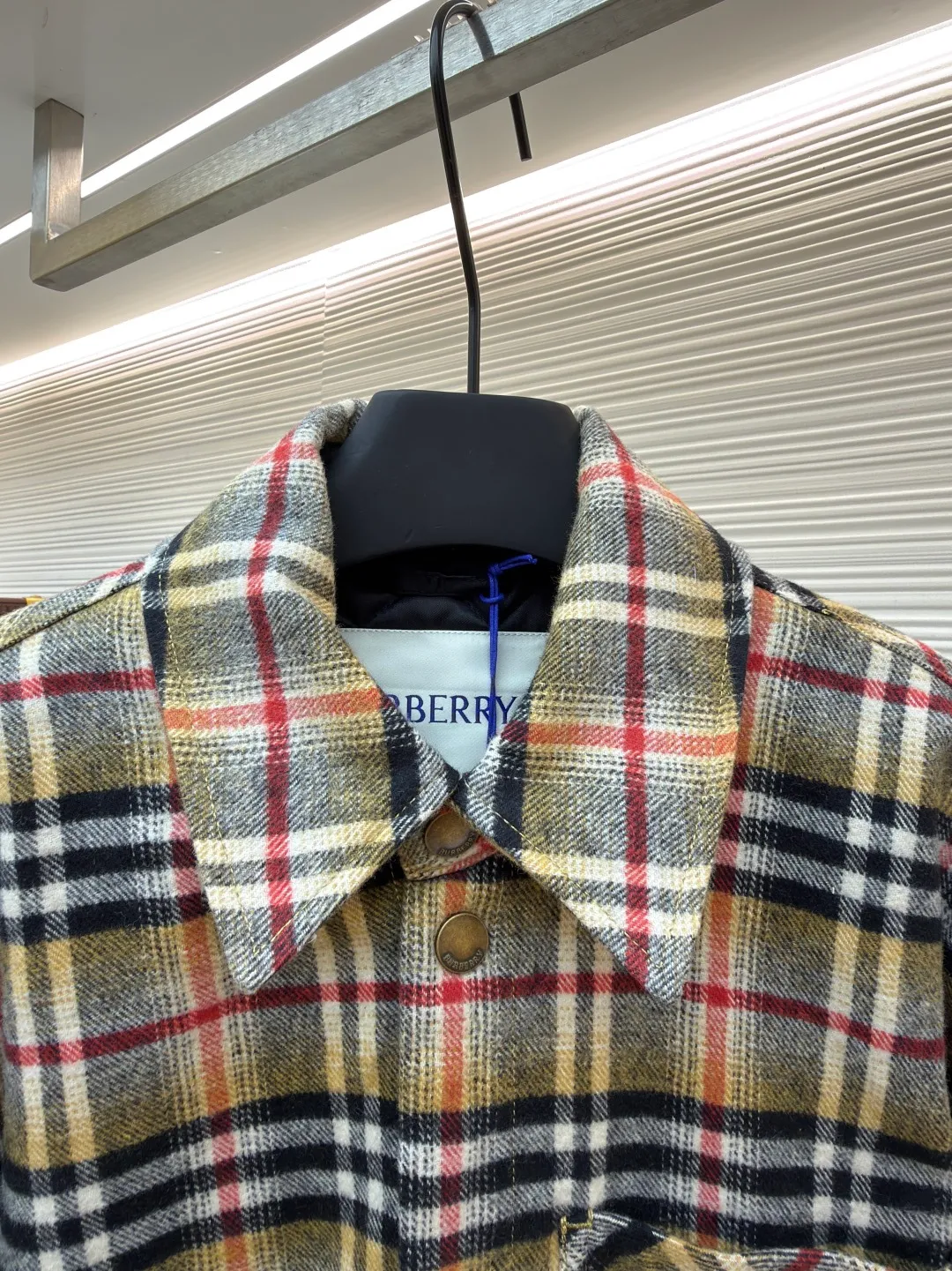 Burberry plaid wool lapel cotton coat ●Original version: Purchased and developed by 7353 ●Item number: 1681919-B40 ●Fabric: wool blended fabric ●Technology: Made on positioning cutting machine ●Color: Khaki ●Version: Fitted version ●Weight: about 800 grams ●Size: S-M-L-XL ●Description: This plaid shirt-style jacket is made of mixed-color wool blend fabric. It is combed to enhance the velvet feel and warmth, and the surface presents a natural variegated texture. The plaid pattern is based on khaki, with gray and red contrasting lines superimposed. The positioning printing process ensures that the plaid pattern is aligned when the pieces are spliced. The placket is made of vintage metal snaps, which are wear-resistant and have a thick texture; the left chest patch pocket is designed with diagonal splicing, and the bag mouth is reinforced with double-line sewing. The neckline is a classic lapel with seamed edges; the cuffs are single-button adjustable, and the inner lining is made of cotton of the same color to improve wearing comfort. The overall stitching density reaches 12 stitches/inch, and the double hemming process on the hem enhances durability. It is suitable for layering or single wear in autumn and winter. The overall wiring is straight and delicate, the fabric is comfortable and soft, and the color is consistent without color difference. It can be matched with the same style to create a fashionable look and control various occasions. Customized accessories, complete with three standards, same style for men and women!