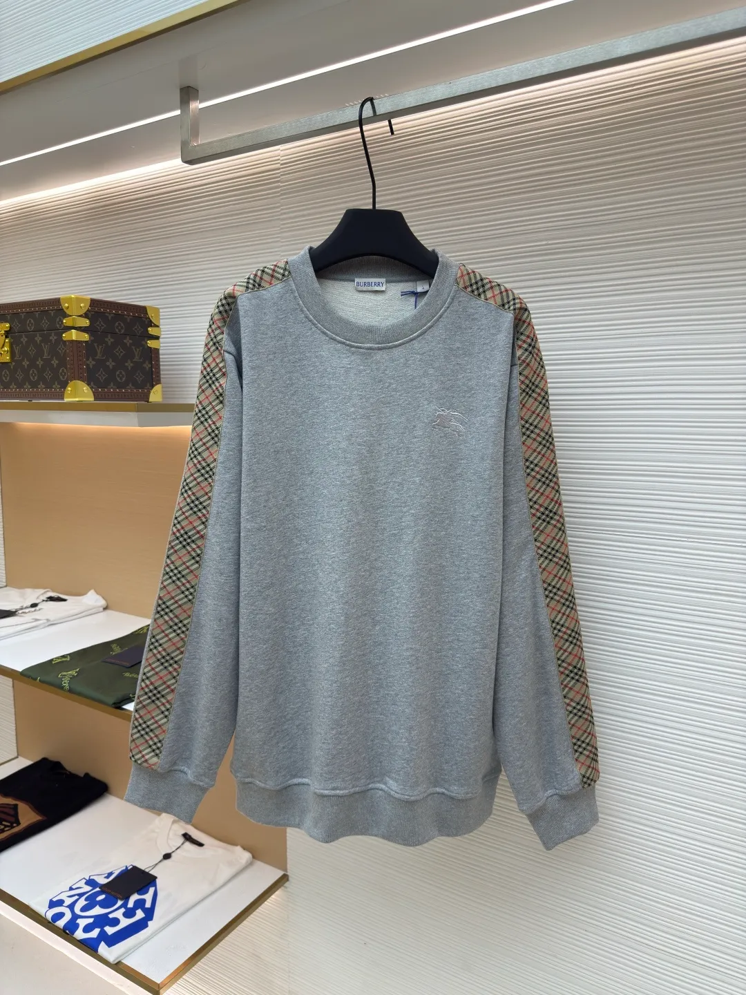 BURBERRY webbing trim round neck sweatshirt ●Authentic product: purchased and developed by 6155 ●Item number: 1680512-A85 ●Fabric: single-sided fish scale fabric ●Technology: selvedge production ●Version: fitted version ●Weight: about 645 grams ●Size: S-M-L-XL ●Description: A single-sided fish-scale cloth fabric woven with cotton as the base. The front is a smooth knitted surface, and the skin-contacting surface is formed into three-dimensional terry by the floating thread knitting technology of the knitting machine, which increases the fluffiness and has a delicate touch. The terry structure absorbs a large amount of water and evaporates quickly, so it is not easy to loosen and deform after repeated washing. By actively interfering with the shrinkage potential of cotton fibers, the fabric is able to transition from changeable to stable, improving dimensional stability while being less prone to deformation and wrinkles. The monochrome flat embroidery on the chest uses the high-precision calculation system of the computer embroidery machine to control the coordinated operation of the machine head, needle bar, and thread spool. The fabric frame moves accurately in the horizontal and vertical directions to form a stitch track. The upper and lower thread tensions are adjusted to ensure that the stitches are smooth and free of floating threads, forming a fine pattern with an error of ±0.1mm. The overall wiring is straight and delicate, the fabric is comfortable and soft, and the color is consistent without color difference. It can be matched with the same style to create a fashionable look and control various occasions. Customized accessories, complete with three standards, same style for men and women!