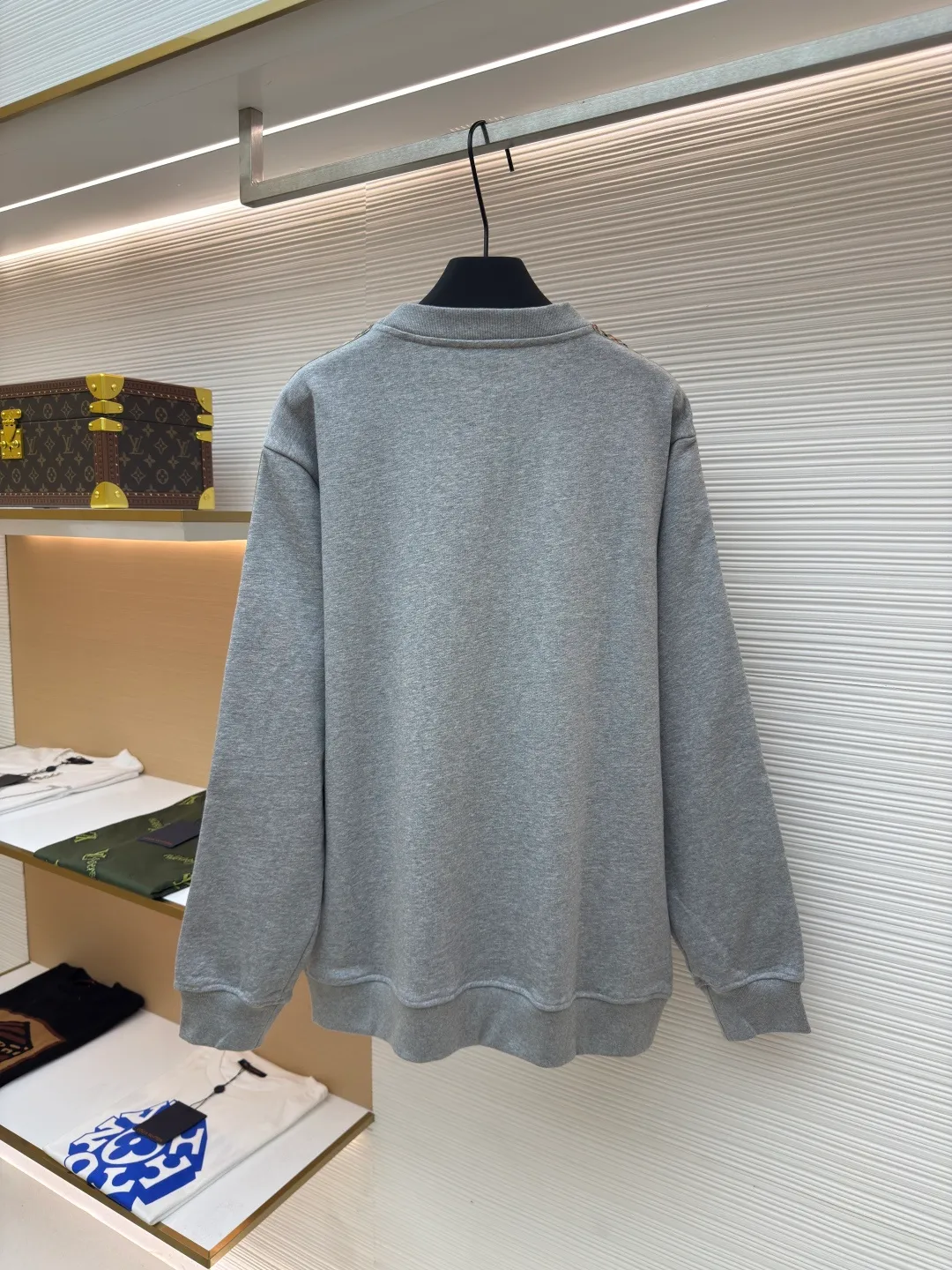 BURBERRY webbing trim round neck sweatshirt ●Authentic product: purchased and developed by 6155 ●Item number: 1680512-A85 ●Fabric: single-sided fish scale fabric ●Technology: selvedge production ●Version: fitted version ●Weight: about 645 grams ●Size: S-M-L-XL ●Description: A single-sided fish-scale cloth fabric woven with cotton as the base. The front is a smooth knitted surface, and the skin-contacting surface is formed into three-dimensional terry by the floating thread knitting technology of the knitting machine, which increases the fluffiness and has a delicate touch. The terry structure absorbs a large amount of water and evaporates quickly, so it is not easy to loosen and deform after repeated washing. By actively interfering with the shrinkage potential of cotton fibers, the fabric is able to transition from changeable to stable, improving dimensional stability while being less prone to deformation and wrinkles. The monochrome flat embroidery on the chest uses the high-precision calculation system of the computer embroidery machine to control the coordinated operation of the machine head, needle bar, and thread spool. The fabric frame moves accurately in the horizontal and vertical directions to form a stitch track. The upper and lower thread tensions are adjusted to ensure that the stitches are smooth and free of floating threads, forming a fine pattern with an error of ±0.1mm. The overall wiring is straight and delicate, the fabric is comfortable and soft, and the color is consistent without color difference. It can be matched with the same style to create a fashionable look and control various occasions. Customized accessories, complete with three standards, same style for men and women!