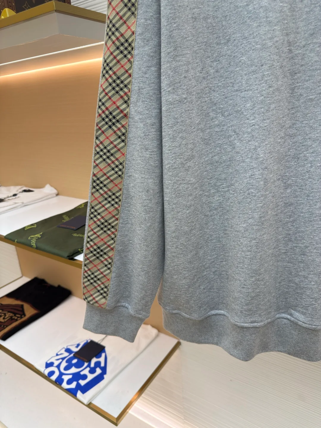 BURBERRY webbing trim round neck sweatshirt ●Authentic product: purchased and developed by 6155 ●Item number: 1680512-A85 ●Fabric: single-sided fish scale fabric ●Technology: selvedge production ●Version: fitted version ●Weight: about 645 grams ●Size: S-M-L-XL ●Description: A single-sided fish-scale cloth fabric woven with cotton as the base. The front is a smooth knitted surface, and the skin-contacting surface is formed into three-dimensional terry by the floating thread knitting technology of the knitting machine, which increases the fluffiness and has a delicate touch. The terry structure absorbs a large amount of water and evaporates quickly, so it is not easy to loosen and deform after repeated washing. By actively interfering with the shrinkage potential of cotton fibers, the fabric is able to transition from changeable to stable, improving dimensional stability while being less prone to deformation and wrinkles. The monochrome flat embroidery on the chest uses the high-precision calculation system of the computer embroidery machine to control the coordinated operation of the machine head, needle bar, and thread spool. The fabric frame moves accurately in the horizontal and vertical directions to form a stitch track. The upper and lower thread tensions are adjusted to ensure that the stitches are smooth and free of floating threads, forming a fine pattern with an error of ±0.1mm. The overall wiring is straight and delicate, the fabric is comfortable and soft, and the color is consistent without color difference. It can be matched with the same style to create a fashionable look and control various occasions. Customized accessories, complete with three standards, same style for men and women!