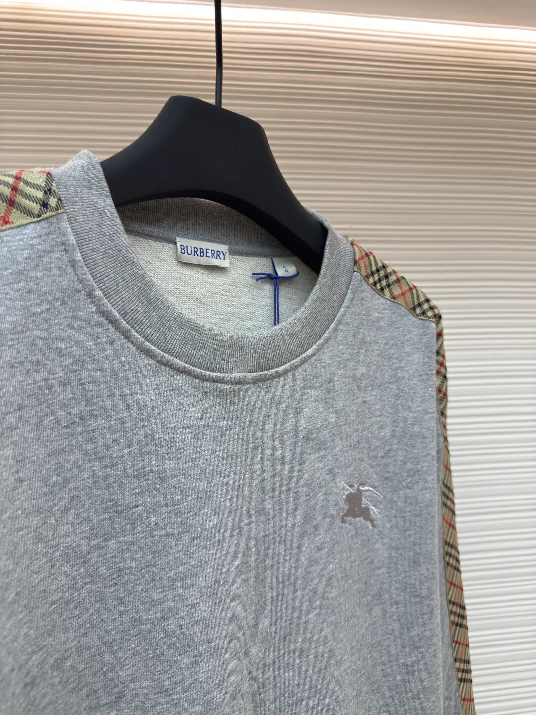 BURBERRY webbing trim round neck sweatshirt ●Authentic product: purchased and developed by 6155 ●Item number: 1680512-A85 ●Fabric: single-sided fish scale fabric ●Technology: selvedge production ●Version: fitted version ●Weight: about 645 grams ●Size: S-M-L-XL ●Description: A single-sided fish-scale cloth fabric woven with cotton as the base. The front is a smooth knitted surface, and the skin-contacting surface is formed into three-dimensional terry by the floating thread knitting technology of the knitting machine, which increases the fluffiness and has a delicate touch. The terry structure absorbs a large amount of water and evaporates quickly, so it is not easy to loosen and deform after repeated washing. By actively interfering with the shrinkage potential of cotton fibers, the fabric is able to transition from changeable to stable, improving dimensional stability while being less prone to deformation and wrinkles. The monochrome flat embroidery on the chest uses the high-precision calculation system of the computer embroidery machine to control the coordinated operation of the machine head, needle bar, and thread spool. The fabric frame moves accurately in the horizontal and vertical directions to form a stitch track. The upper and lower thread tensions are adjusted to ensure that the stitches are smooth and free of floating threads, forming a fine pattern with an error of ±0.1mm. The overall wiring is straight and delicate, the fabric is comfortable and soft, and the color is consistent without color difference. It can be matched with the same style to create a fashionable look and control various occasions. Customized accessories, complete with three standards, same style for men and women!