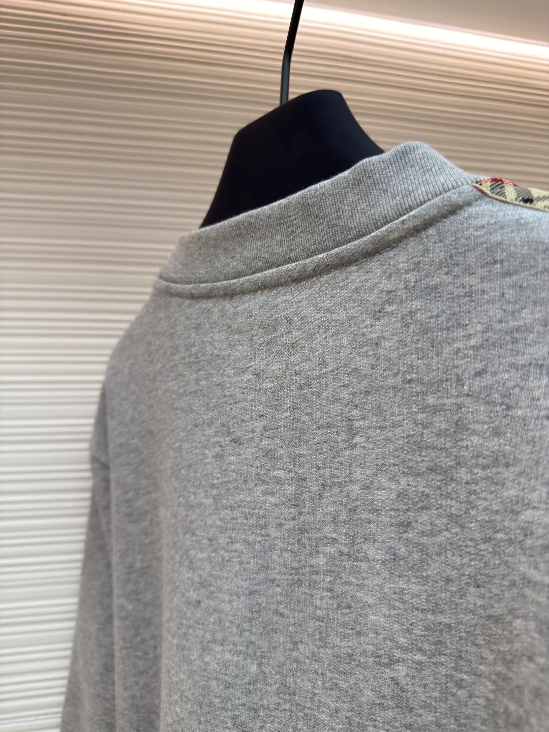 BURBERRY webbing trim round neck sweatshirt ●Authentic product: purchased and developed by 6155 ●Item number: 1680512-A85 ●Fabric: single-sided fish scale fabric ●Technology: selvedge production ●Version: fitted version ●Weight: about 645 grams ●Size: S-M-L-XL ●Description: A single-sided fish-scale cloth fabric woven with cotton as the base. The front is a smooth knitted surface, and the skin-contacting surface is formed into three-dimensional terry by the floating thread knitting technology of the knitting machine, which increases the fluffiness and has a delicate touch. The terry structure absorbs a large amount of water and evaporates quickly, so it is not easy to loosen and deform after repeated washing. By actively interfering with the shrinkage potential of cotton fibers, the fabric is able to transition from changeable to stable, improving dimensional stability while being less prone to deformation and wrinkles. The monochrome flat embroidery on the chest uses the high-precision calculation system of the computer embroidery machine to control the coordinated operation of the machine head, needle bar, and thread spool. The fabric frame moves accurately in the horizontal and vertical directions to form a stitch track. The upper and lower thread tensions are adjusted to ensure that the stitches are smooth and free of floating threads, forming a fine pattern with an error of ±0.1mm. The overall wiring is straight and delicate, the fabric is comfortable and soft, and the color is consistent without color difference. It can be matched with the same style to create a fashionable look and control various occasions. Customized accessories, complete with three standards, same style for men and women!