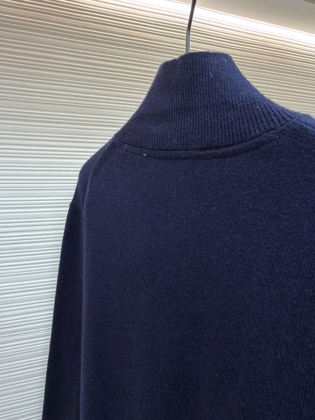 Burberry embroidered half-zip turtleneck sweater ●Original version: Purchased and developed by 4472 ●Item number: 1681783-B25 ●Material: wool blended fabric ●Technology: knitted production ●Color: navy ●Version: Fitted version ●Weight: about 545 grams ●Size: S-M-L-XL ●Description: Cashmere is used as the main body to dominate the feel, warmth and lightness of the fabric, while providing an unparalleled wearing experience. A small amount of polyamide and Lycra are added to enhance the overall durability and pilling resistance. An invisible support network is woven into the soft cashmere, and it also has a certain amount of elasticity to better fit the curves of the human body and allow it to be retracted and retracted freely. Due to the characteristics of the sweater fabric, it is stretched just right when stretching the frame, and then a hot-melt liner is used under the wool fabric piece to provide it with a certain temporary stable support to prevent it from shrinking after removal, causing pattern distortion, wrinkles and stitch dents. The high-precision calculation program system of the computer embroidery machine controls the movement of the embroidery frame in the X/Y direction, while the needle shuttles up and down, embroidering according to the set path, automatically completing thread trimming, thread jumping and other actions to form a stitch track, automatically adjusting the upper and lower thread tension to ensure that the stitches are smooth and free of floating threads, forming a war horse pattern with an error of ±0.1mm. Add detergent and preliminarily rinse the bulk goods at a water temperature of about 35 degrees to remove impurities during the production process, and then use protease to gently digest the hairiness on the surface to reduce the tendency of pilling from the root, improve the hand feel, retain softness, and eliminate irritation. After the final dehydration and drying process, the overall wiring is straight and delicate, the fabric is comfortable and soft, and the color is consistent without color difference. It can be matched with the same style to create a fashionable look and control various occasions. Customized accessories, complete with three standards, same style for men and women!
