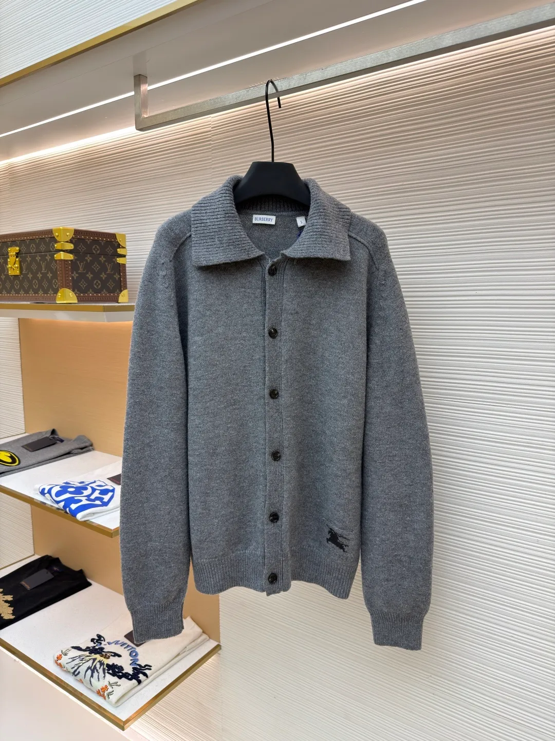 Burberry lapel rib knitted cashmere sweater ●Original version: purchased and developed by 11575 ●Item number: 1682227-B15 ●Fabric: wool blended fabric ●Technology: knitted ●Color: gray ●Version: fitted version ●Weight: about 580 grams ●Size: S-M-L-XL ●Description: This black knitted cardigan is knitted with high-count worsted wool yarn. The main body is built using four-flat stitch technology, which gives the fabric good elasticity and shapeability, while forming a fine and tight texture. The ribbed lapel weaving process is used at the neckline, and a combination of different needle types is used to create a crisp collar profile. The rib structure can be freely expanded and contracted according to the wearing status to fit the neck line. The placket adopts inlaid buttonhole technology and is matched with matte resin buttons of the same color. The buttons and the body are fixed by hand-stitching, which is strong and beautiful. The brand logo patch on the lower side of the body is processed by a hot-pressing bonding process and fits seamlessly with the knitted fabric. The overall cut is a slightly loose shoulder-drop version, combined with three-dimensional darting technology, which ensures wearing comfort while creating clean lines. Every knitting node is manually inspected to ensure the uniformity and integrity of the knitted texture. The overall wiring is straight and delicate, the fabric is comfortable and soft, and the color is consistent without color difference. It can be matched with the same style to create a fashionable look and control various occasions. Customized accessories, complete with three standards, same style for men and women!