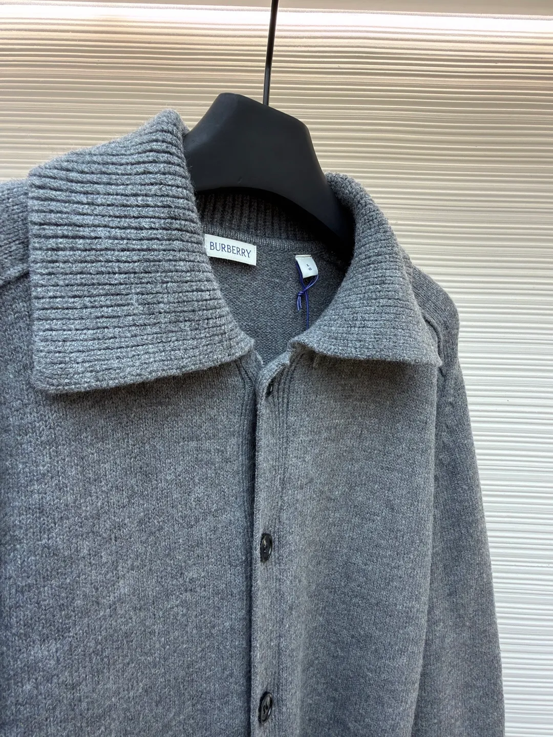 Burberry lapel rib knitted cashmere sweater ●Original version: purchased and developed by 11575 ●Item number: 1682227-B15 ●Fabric: wool blended fabric ●Technology: knitted ●Color: gray ●Version: fitted version ●Weight: about 580 grams ●Size: S-M-L-XL ●Description: This black knitted cardigan is knitted with high-count worsted wool yarn. The main body is built using four-flat stitch technology, which gives the fabric good elasticity and shapeability, while forming a fine and tight texture. The ribbed lapel weaving process is used at the neckline, and a combination of different needle types is used to create a crisp collar profile. The rib structure can be freely expanded and contracted according to the wearing status to fit the neck line. The placket adopts inlaid buttonhole technology and is matched with matte resin buttons of the same color. The buttons and the body are fixed by hand-stitching, which is strong and beautiful. The brand logo patch on the lower side of the body is processed by a hot-pressing bonding process and fits seamlessly with the knitted fabric. The overall cut is a slightly loose shoulder-drop version, combined with three-dimensional darting technology, which ensures wearing comfort while creating clean lines. Every knitting node is manually inspected to ensure the uniformity and integrity of the knitted texture. The overall wiring is straight and delicate, the fabric is comfortable and soft, and the color is consistent without color difference. It can be matched with the same style to create a fashionable look and control various occasions. Customized accessories, complete with three standards, same style for men and women!