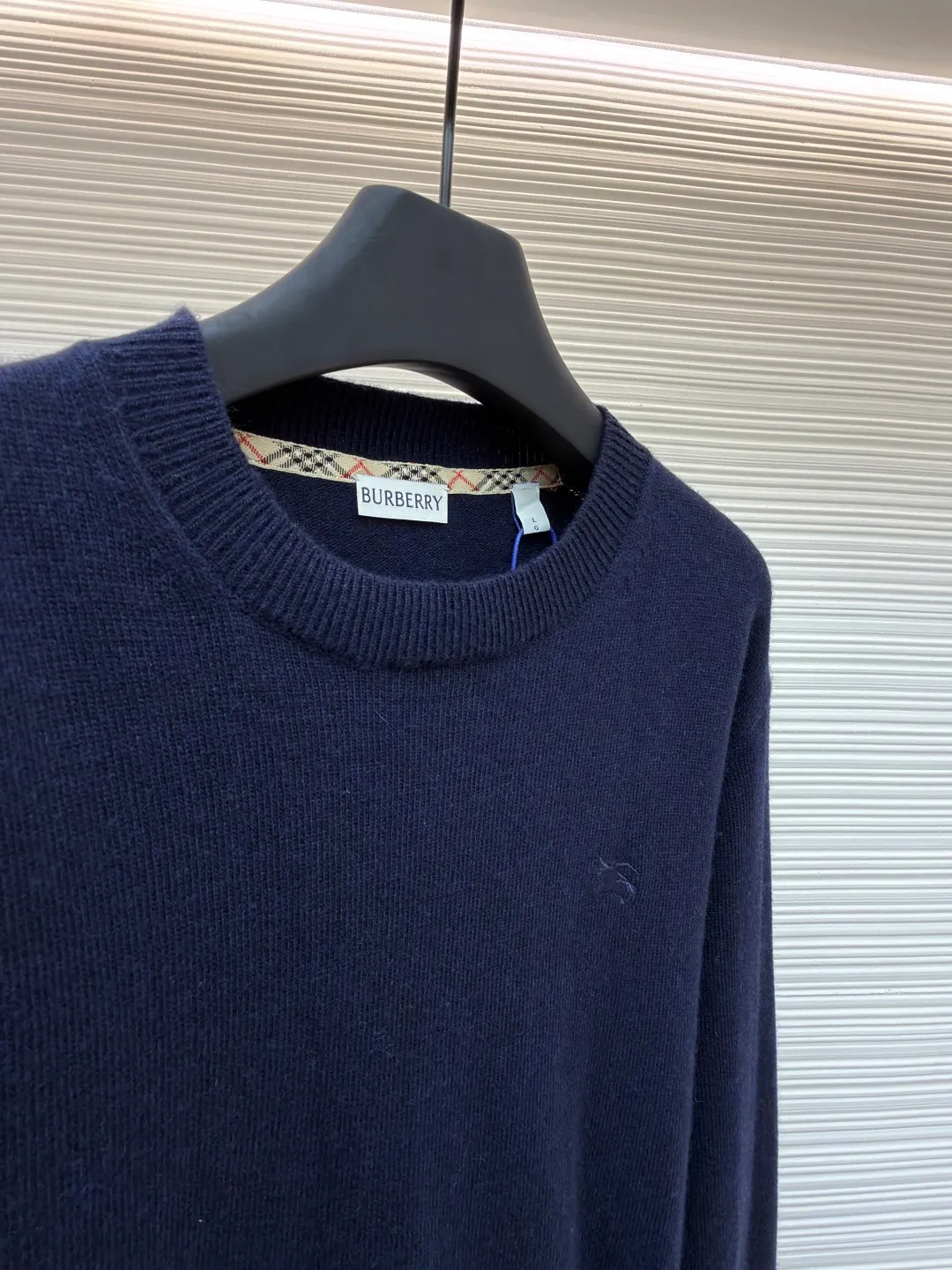 Burberry embroidered crew neck sweater ●Original version: Purchased and developed for 1499 ●Item number: 1681780-B25 ●Fabric: wool blended fabric ●Technology: knitted ●Color: navy ●Version: Fitted version ●Weight: about 465 grams ●Size: S-M-L-XL ●Description: Cashmere is used as the main body to dominate the feel, warmth and lightness of the fabric, while providing an unparalleled wearing experience. A small amount of polyamide and Lycra are added to enhance the overall durability and pilling resistance. An invisible support network is woven into the soft cashmere, and it also has a certain amount of elasticity to better fit the curves of the human body and allow it to be retracted and retracted freely. The ribbed decorative parts of the collar and cuffs are made of blended fabrics of the same proportion, which further enhances the texture and wearing experience. Due to the characteristics of the sweater fabric, it is stretched just right when stretching the frame, and then a hot-melt liner is used under the wool fabric piece to provide it with a certain temporary stable support to prevent it from shrinking after removal, causing pattern distortion, wrinkles and stitch dents. The high-precision calculation program system of the computer embroidery machine controls the movement of the embroidery frame in the X/Y direction, while the needle shuttles up and down, embroidering according to the set path, automatically completing thread trimming, thread jumping and other actions to form a stitch track, automatically adjusting the upper and lower thread tension to ensure that the stitches are smooth and free of floating threads, forming a war horse pattern with an error of ±0.1mm. Add detergent and preliminarily rinse the bulk goods at a water temperature of about 35 degrees to remove impurities during the production process, and then use protease to gently digest the hairiness on the surface to reduce the tendency of pilling from the root, improve the hand feel, retain softness, and eliminate irritation. Finally, after dehydration and drying, the dimensional and shape stability is improved. The overall wiring is straight and delicate, the fabric is comfortable and soft, and the color is consistent without color difference. It can be matched with the same style to create a fashionable look and control various occasions. Customized accessories, complete with three standards, same style for men and women!