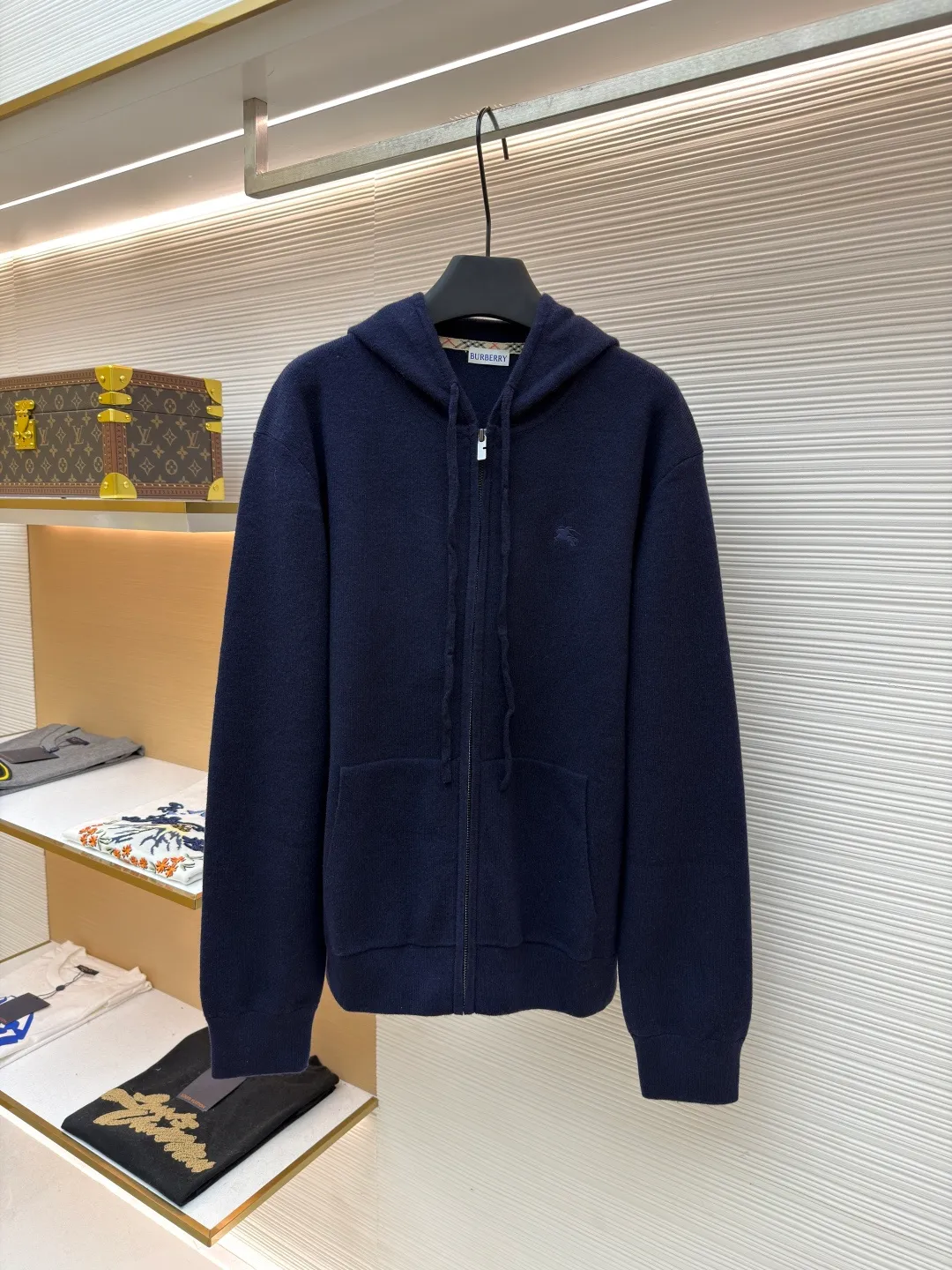 Burberry embroidered zipper cardigan ●Original version: Purchased and developed by 4766 ●Item number: 1681788-B70 ●Fabric: wool blended fabric ●Technology: knitted ●Color: navy ●Version: Fitted version ●Weight: about 875 grams ●Size: S-M-L-XL ●Description: Cashmere is the main material that dominates the feel, warmth and lightness of the fabric, while providing an unparalleled wearing experience. A small amount of polyamide and elastic fiber are added to enhance the overall durability and anti-pilling properties. An invisible support network is woven into the soft cashmere, and at the same time it has a certain amount of elasticity, which better fits the curves of the human body and can be retracted and retracted freely. Due to the characteristics of the sweater fabric, it is stretched just right when stretching the frame, and then a hot-melt liner is used under the wool fabric piece to provide it with a certain temporary stable support to prevent it from shrinking after removal, causing pattern distortion, wrinkles and stitch dents. The high-precision calculation program system of the computer embroidery machine controls the movement of the embroidery frame in the X/Y direction, while the needle shuttles up and down, embroidering according to the set path, automatically completing thread trimming, thread jumping and other actions to form a stitch track, automatically adjusting the upper and lower thread tension to ensure that the stitches are smooth and free of floating threads, forming a war horse pattern with an error of ±0.1mm. Add detergent and preliminarily rinse the bulk goods at a water temperature of about 35 degrees to remove impurities during the production process, and then use protease to gently digest the hairiness on the surface to reduce the tendency of pilling from the root, improve the hand feel, retain softness, and eliminate irritation. Finally, after dehydration and drying, the size and shape are stabilized. The overall wiring is straight and delicate, the fabric is comfortable and soft, and the color is consistent without color difference. It can be matched with the same style to create a fashionable look and control various occasions. Customized accessories, complete with three standards, same style for men and women!