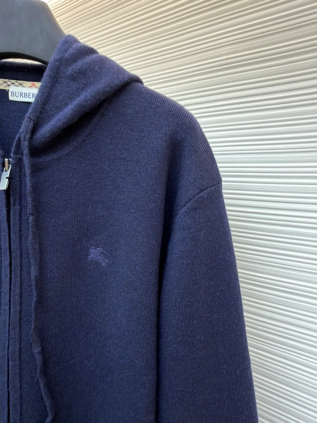 Burberry embroidered zipper cardigan ●Original version: Purchased and developed by 4766 ●Item number: 1681788-B70 ●Fabric: wool blended fabric ●Technology: knitted ●Color: navy ●Version: Fitted version ●Weight: about 875 grams ●Size: S-M-L-XL ●Description: Cashmere is the main material that dominates the feel, warmth and lightness of the fabric, while providing an unparalleled wearing experience. A small amount of polyamide and elastic fiber are added to enhance the overall durability and anti-pilling properties. An invisible support network is woven into the soft cashmere, and at the same time it has a certain amount of elasticity, which better fits the curves of the human body and can be retracted and retracted freely. Due to the characteristics of the sweater fabric, it is stretched just right when stretching the frame, and then a hot-melt liner is used under the wool fabric piece to provide it with a certain temporary stable support to prevent it from shrinking after removal, causing pattern distortion, wrinkles and stitch dents. The high-precision calculation program system of the computer embroidery machine controls the movement of the embroidery frame in the X/Y direction, while the needle shuttles up and down, embroidering according to the set path, automatically completing thread trimming, thread jumping and other actions to form a stitch track, automatically adjusting the upper and lower thread tension to ensure that the stitches are smooth and free of floating threads, forming a war horse pattern with an error of ±0.1mm. Add detergent and preliminarily rinse the bulk goods at a water temperature of about 35 degrees to remove impurities during the production process, and then use protease to gently digest the hairiness on the surface to reduce the tendency of pilling from the root, improve the hand feel, retain softness, and eliminate irritation. Finally, after dehydration and drying, the size and shape are stabilized. The overall wiring is straight and delicate, the fabric is comfortable and soft, and the color is consistent without color difference. It can be matched with the same style to create a fashionable look and control various occasions. Customized accessories, complete with three standards, same style for men and women!