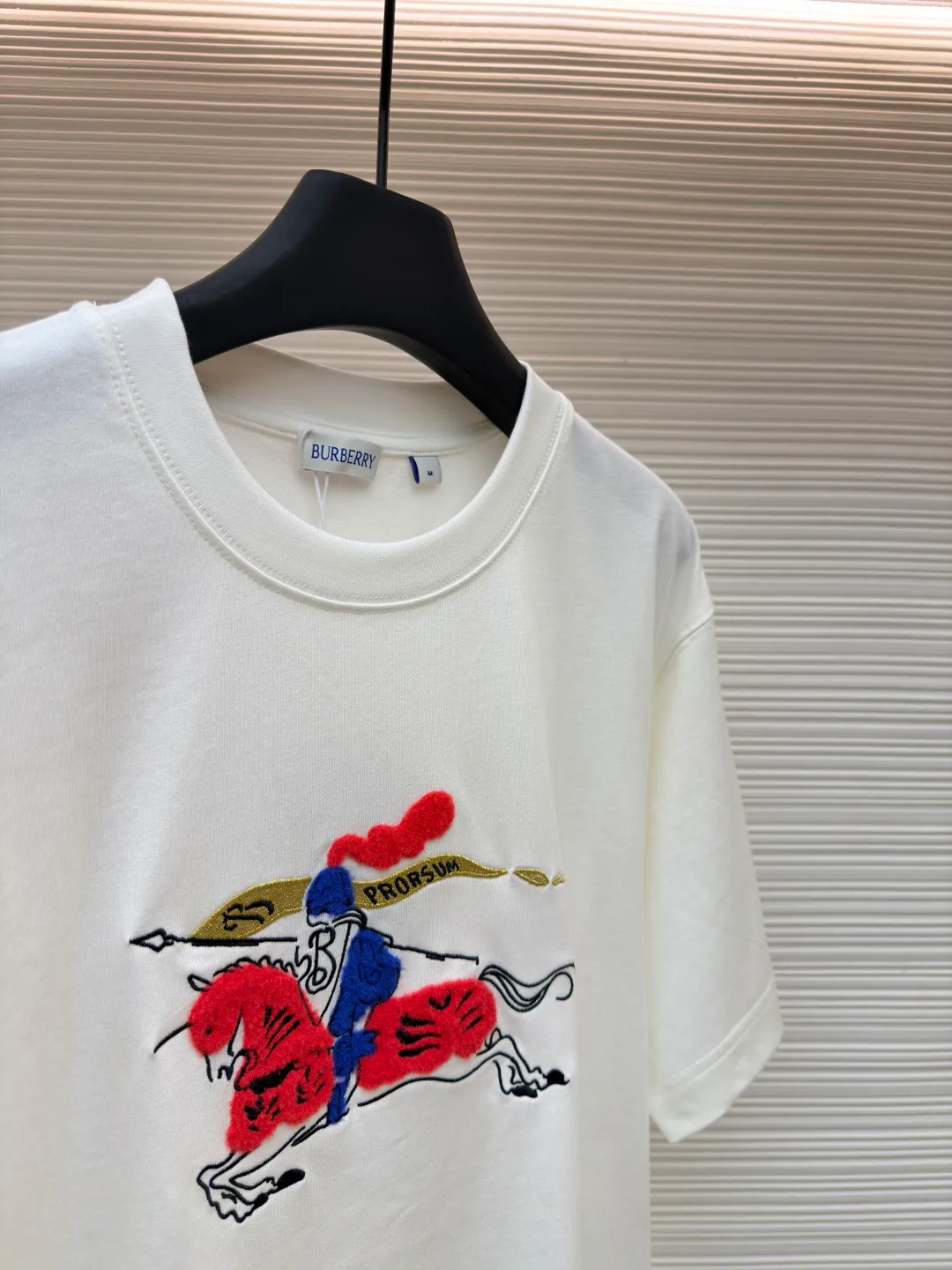 Burberry fleece pony round neck short sleeves ●Original version: Purchased and developed by 4242 ●Item number: 1682164-A05 ●Fabric: pure cotton plain weave ●Technology: embroidery production ●Color: white ●Version: fitted version ●Weight: about 270 grams ●Size: Fine cotton fabrics usually have better moisture absorption, breathability, wear resistance, and are also softer and smoother. Vintage fine cotton fabric is a relatively thick cotton fabric that has been carefully processed and treated to have excellent texture and performance. It feels soft and comfortable and fits the skin very well when worn. Craftsmanship with plush effect, new season equestrian knight logo embroidery, and metallic yarns with a rich touch are the core of the design. During the embroidery process, special yarns containing metallic threads are mixed and programmed through a computer embroidery machine to integrate the metallic yarns into specific parts of the pattern using stitching methods such as chain embroidery and tatami embroidery. On top of the traditional three-dimensional sense of embroidery, a shimmering metallic luster and a special cool touch are added, causing the classic logo pattern to produce local highlights under light, showing a reshaped modern sense and a high-end customization-like sophistication, which is highly recognizable. The overall wiring is straight and delicate, the fabric is comfortable and soft, and the color is consistent without color difference. It can be matched with the same style to create a fashionable look and control various occasions. Customized accessories, complete with three standards, same style for men and women!