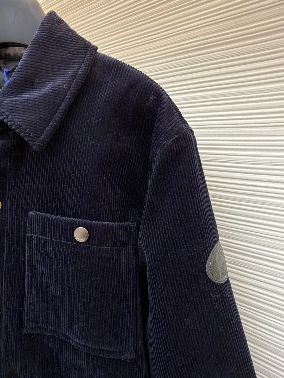 Burberry solid color lapel snap-fastening cotton jacket ●Original version: purchased and developed by 8766 ●Item number: 1681956-B40 ●Fabric: 100% cotton ●Technology: Made on positioning cutting machine ●Color: navy blue ●Version: fitted version ●Weight: about 940 grams ●Size: S-M-L-XL ●Description: This LV navy corduroy jacket is made of 8 wide corduroy fabrics, which are washed and distressed. The velvet strips are full and soft to the touch, while maintaining wrinkle resistance. The body of the garment adopts a whole-piece cutting process to ensure that the vertical texture of the corduroy is consistent and uninterrupted, and the splicing is sewn with invisible embedded clips, making the appearance more tidy. The chest patch pocket is made of double-layer quilted fabric, and the edges of the bag flap are edged with the same material. It is equipped with matte metal snap buttons, and the buckle surface is sandblasted to give a low-key texture. The ribs on the cuffs and hem are made of the same fabric and are elastic to fit the body shape. The left arm decorative plate is made of embossed + vegetable tanned leather splicing, and the brand logo is concealed and three-dimensional. The inner lining is lined with thin nylon interlining to improve the smoothness of putting on and taking off. The overall stitching stitches are evenly spaced (8 stitches per centimeter), taking into account the retro texture and practical durability. The overall wiring is straight and delicate, the fabric is comfortable and soft, and the color is consistent without color difference. It can be matched with the same style to create a fashionable look and control various occasions. Customized accessories, complete with three standards, same style for men and women!
