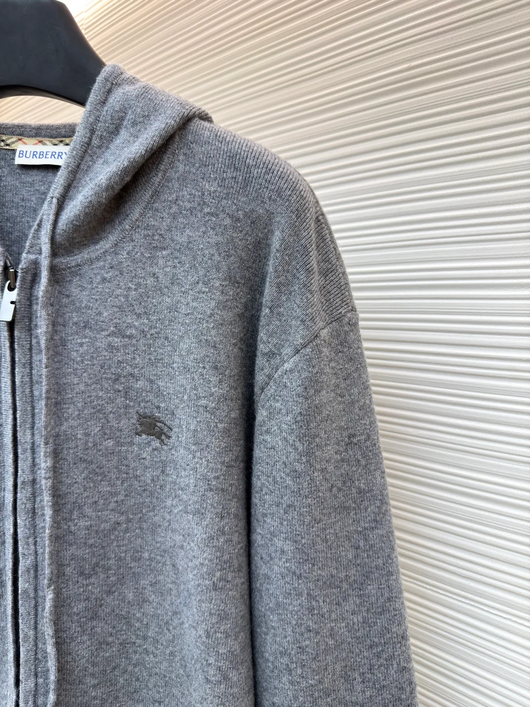 Burberry embroidered zipper cardigan ●Original version: Purchased and developed by 6347 ●Item number: 1681789-B70 ●Fabric: wool blended fabric ●Technology: knitted ●Color: gray ●Version: Fitted version ●Weight: about 905 grams ●Size: S-M-L-XL ●Description: Cashmere is used as the main body to dominate the feel, warmth and lightness of the fabric, while providing an unparalleled wearing experience. A small amount of polyamide and elastic fiber are added to enhance the overall durability and anti-pilling properties. An invisible support network is woven into the soft cashmere, and at the same time it has a certain amount of elasticity, which better fits the curves of the human body and can be retracted and retracted freely. Due to the characteristics of the sweater fabric, it is stretched just right when stretching the frame, and then a hot-melt liner is used under the wool fabric piece to provide it with a certain temporary stable support to prevent it from shrinking after removal, causing pattern distortion, wrinkles and stitch dents. The high-precision calculation program system of the computer embroidery machine controls the movement of the embroidery frame in the X/Y direction, while the needle shuttles up and down, embroidering according to the set path, automatically completing thread trimming, thread jumping and other actions to form a stitch track, automatically adjusting the upper and lower thread tension to ensure that the stitches are smooth and free of floating threads, forming a war horse pattern with an error of ±0.1mm. Add detergent and preliminarily rinse the bulk goods at a water temperature of about 35 degrees to remove impurities during the production process, and then use protease to gently digest the hairiness on the surface to reduce the tendency of pilling from the root, improve the hand feel, retain softness, and eliminate irritation. Finally, after dehydration and drying, the size and shape are stabilized. The overall wiring is straight and delicate, the fabric is comfortable and soft, and the color is consistent without color difference. It can be matched with the same style to create a fashionable look and control various occasions. Customized accessories, complete with three standards, same style for men and women!