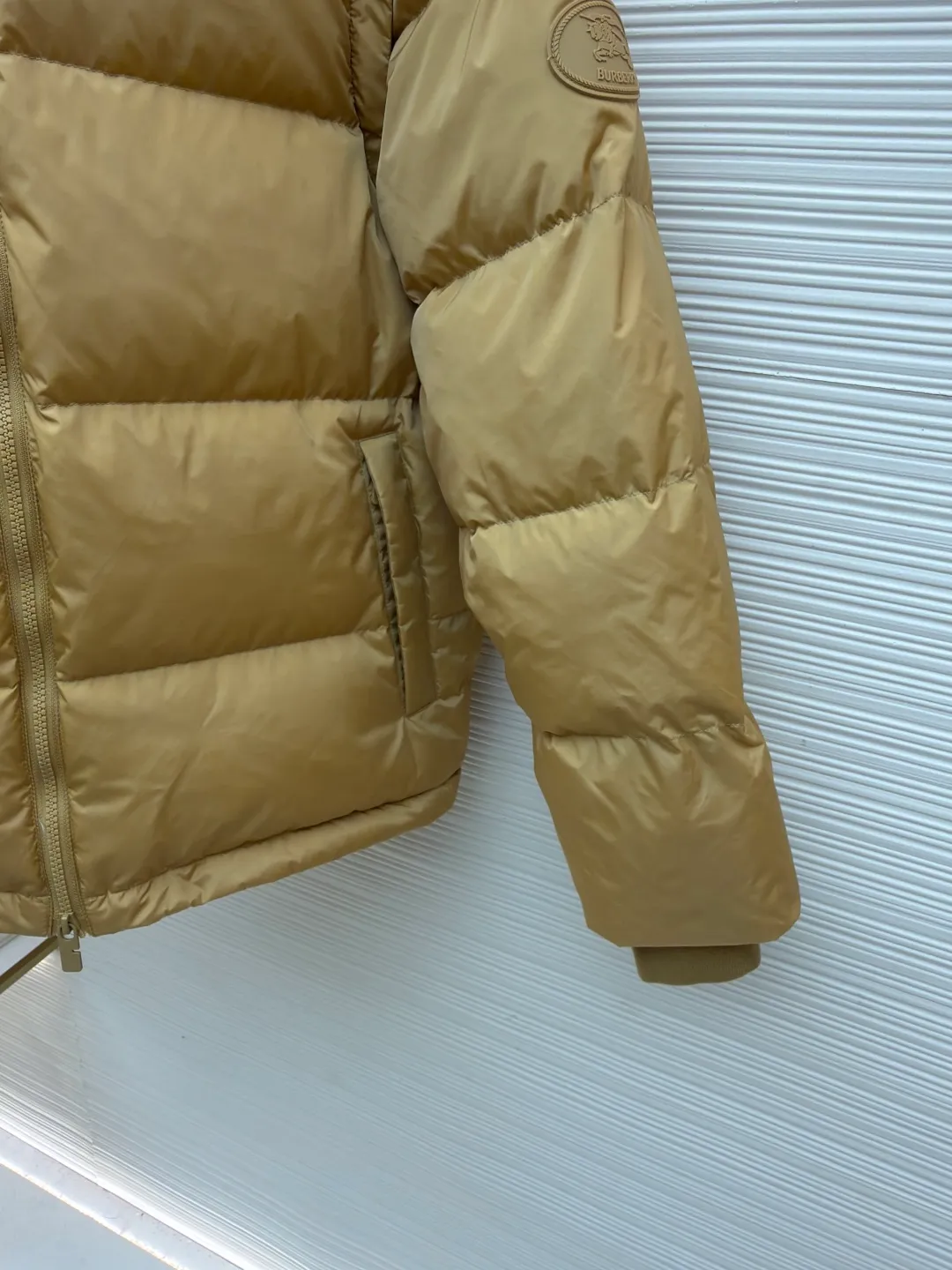 Burberry detachable sleeve down jacket ●Original version: Purchased and developed by 5453 ●Item number: 1682187-C85 ●Fabric: goose down fabric ●Technology: mechanical down filling ●Color: khaki ●Version: fitted version ●Weight: about 1060 grams ●Size: S-M-L-XL ●Description: Filled with goose down and thermal fiber. Decorated with the brand's knight's seal appliqué, inspired by archival graphics from the 1980s. Incorporating detachable sleeve design, you can freely switch between jacket and vest styles. Featuring a relaxed fit, the detachable hood and collar are lined in wool and accented with Burberry check. Two-way zip closure and detachable drawstring hood. Detachable sleeves Side zip pockets Drawstring hem Windproof cuffs Burberry check lining on hood and collar Knight seal appliqué on sleeves. The overall wiring is straight and delicate, the fabric is comfortable and soft, and the color is consistent without color difference. It can be matched with the same style to create a fashionable look and control various occasions. Customized accessories, complete with three standards, same style for men and women!