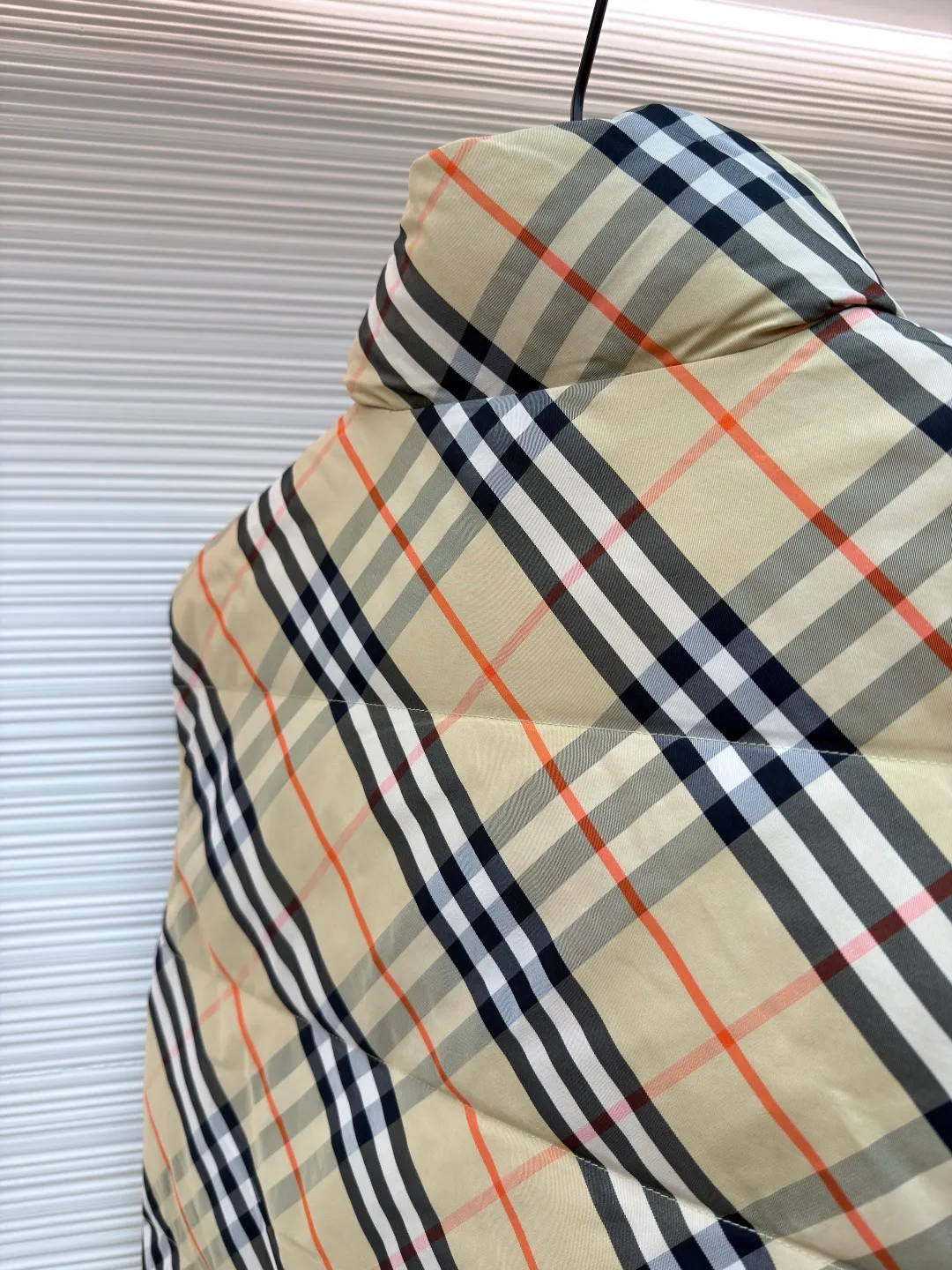 Burberry plaid down vest ●Original version: Purchased and developed by 7064 ●Item number: 1681079-C55 ●Fabric: goose down fabric ●Technology: made on positioning cutting machine ●Version: fitted version ●Weight: about 655 grams ●Size: XS-S-M-L-XL ●Description: Say goodbye to the weight of winter and embrace the warmth with a light attitude. BURBERRY's plaid down vest is crafted from protective nylon fabric and filled with high-quality 90 new national standard white duck down, giving you a warm experience of cloud-like wrapping without fear of severe cold. When the hood is not needed, it can be neatly tucked into the back of the collar, maintaining the smooth silhouette and simple style of the vest, making it perfect for both business and leisure occasions. When the weather changes, you can easily unfold it and you will instantly have a protective hood to cope with sudden wind, rain or cold. This kind of "invisible" protection means that style never compromises due to function. The front chest is decorated with a silicone plaque of the knight's logo from the archives of the 1980s, showing off its extraordinary status in a low-key manner. The two-way zipper opens and closes smoothly, and the side zipper pockets and drawstring hem details combine practical functionality with modern style. Concealed hooded design. The overall wiring is straight and delicate, the fabric is comfortable and soft, and the color is consistent without color difference. It can be matched with the same style to create a fashionable look and control various occasions. Customized accessories, complete with three standards, same style for men and women!