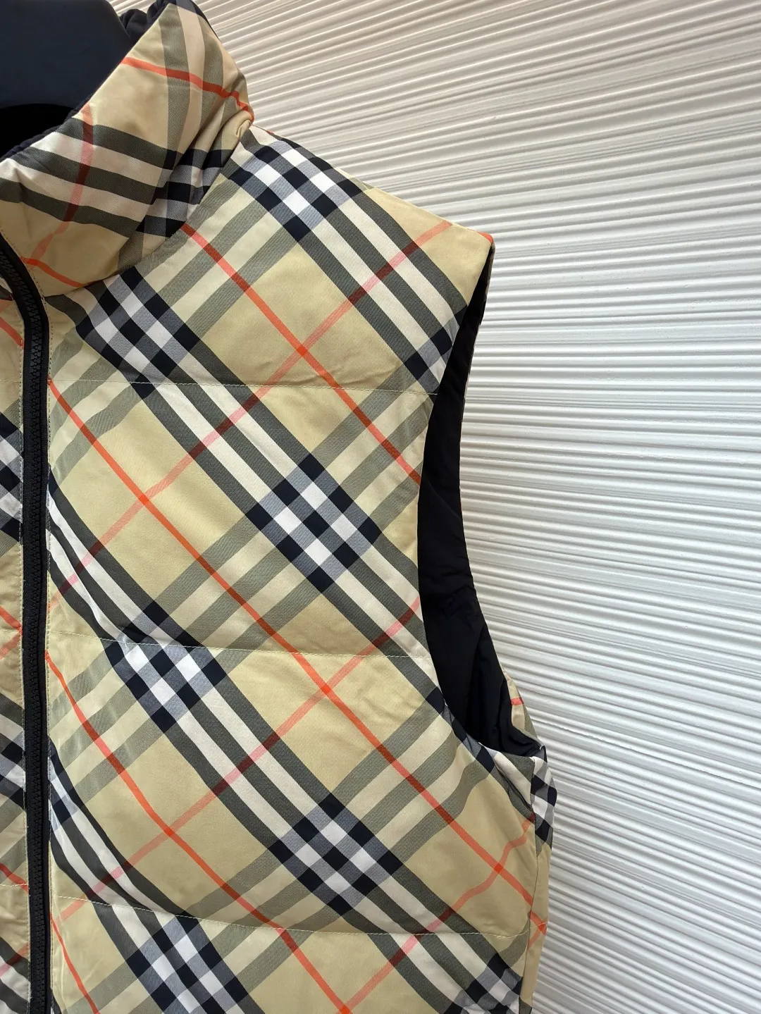 Burberry plaid down vest ●Original version: Purchased and developed by 7064 ●Item number: 1681079-C55 ●Fabric: goose down fabric ●Technology: made on positioning cutting machine ●Version: fitted version ●Weight: about 655 grams ●Size: XS-S-M-L-XL ●Description: Say goodbye to the weight of winter and embrace the warmth with a light attitude. BURBERRY's plaid down vest is crafted from protective nylon fabric and filled with high-quality 90 new national standard white duck down, giving you a warm experience of cloud-like wrapping without fear of severe cold. When the hood is not needed, it can be neatly tucked into the back of the collar, maintaining the smooth silhouette and simple style of the vest, making it perfect for both business and leisure occasions. When the weather changes, you can easily unfold it and you will instantly have a protective hood to cope with sudden wind, rain or cold. This kind of "invisible" protection means that style never compromises due to function. The front chest is decorated with a silicone plaque of the knight's logo from the archives of the 1980s, showing off its extraordinary status in a low-key manner. The two-way zipper opens and closes smoothly, and the side zipper pockets and drawstring hem details combine practical functionality with modern style. Concealed hooded design. The overall wiring is straight and delicate, the fabric is comfortable and soft, and the color is consistent without color difference. It can be matched with the same style to create a fashionable look and control various occasions. Customized accessories, complete with three standards, same style for men and women!