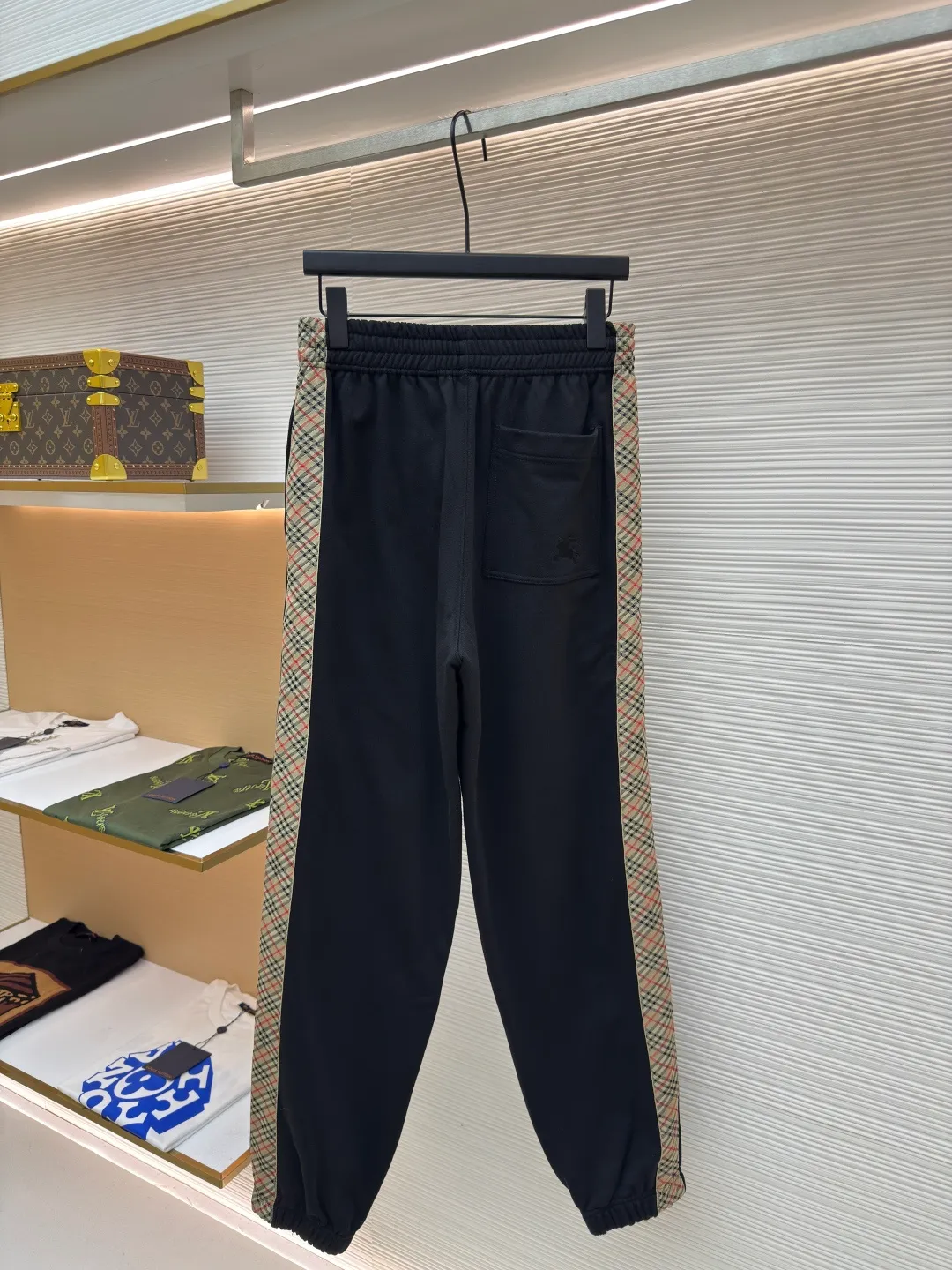 BURBERRY plaid webbing embroidered sweatpants ●Authentic product: purchased and developed by 3162 ●Item number: 1680514-A95 ●Fabric: single-sided fish scale fabric ●Technology: selvedge production ●Version: fitted version ●Weight: about 725 grams ●Size: S-M-L-XL ●Description: A single-sided fish-scale cloth fabric woven with cotton as the base. The front is a smooth knitted surface, and the skin-contacting surface is formed into three-dimensional terry by the floating thread knitting technology of the knitting machine, which increases the fluffiness and has a delicate touch. The terry structure absorbs a large amount of water and evaporates quickly, so it is not easy to loosen and deform after repeated washing. By actively interfering with the shrinkage potential of cotton fibers, the fabric is able to transition from changeable to stable, improving dimensional stability while being less prone to deformation and wrinkles. The monochrome flat embroidery on the chest uses the high-precision calculation system of the computer embroidery machine to control the coordinated operation of the machine head, needle bar, and thread spool. The fabric frame moves accurately in the horizontal and vertical directions to form a stitch track. The upper and lower thread tensions are adjusted to ensure that the stitches are smooth and free of floating threads, forming a fine pattern with an error of ±0.1mm. The overall wiring is straight and delicate, the fabric is comfortable and soft, and the color is consistent without color difference. It can be matched with the same style to create a fashionable look and control various occasions. Customized accessories, complete with three standards, same style for men and women!