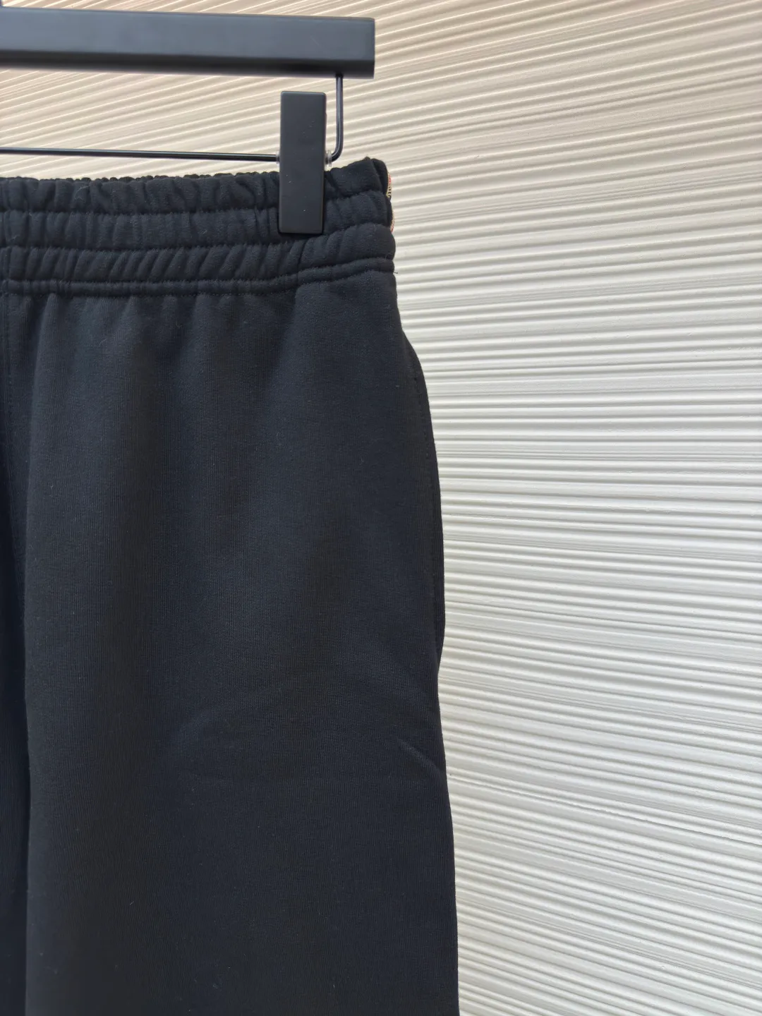 BURBERRY plaid webbing embroidered sweatpants ●Authentic product: purchased and developed by 3162 ●Item number: 1680514-A95 ●Fabric: single-sided fish scale fabric ●Technology: selvedge production ●Version: fitted version ●Weight: about 725 grams ●Size: S-M-L-XL ●Description: A single-sided fish-scale cloth fabric woven with cotton as the base. The front is a smooth knitted surface, and the skin-contacting surface is formed into three-dimensional terry by the floating thread knitting technology of the knitting machine, which increases the fluffiness and has a delicate touch. The terry structure absorbs a large amount of water and evaporates quickly, so it is not easy to loosen and deform after repeated washing. By actively interfering with the shrinkage potential of cotton fibers, the fabric is able to transition from changeable to stable, improving dimensional stability while being less prone to deformation and wrinkles. The monochrome flat embroidery on the chest uses the high-precision calculation system of the computer embroidery machine to control the coordinated operation of the machine head, needle bar, and thread spool. The fabric frame moves accurately in the horizontal and vertical directions to form a stitch track. The upper and lower thread tensions are adjusted to ensure that the stitches are smooth and free of floating threads, forming a fine pattern with an error of ±0.1mm. The overall wiring is straight and delicate, the fabric is comfortable and soft, and the color is consistent without color difference. It can be matched with the same style to create a fashionable look and control various occasions. Customized accessories, complete with three standards, same style for men and women!