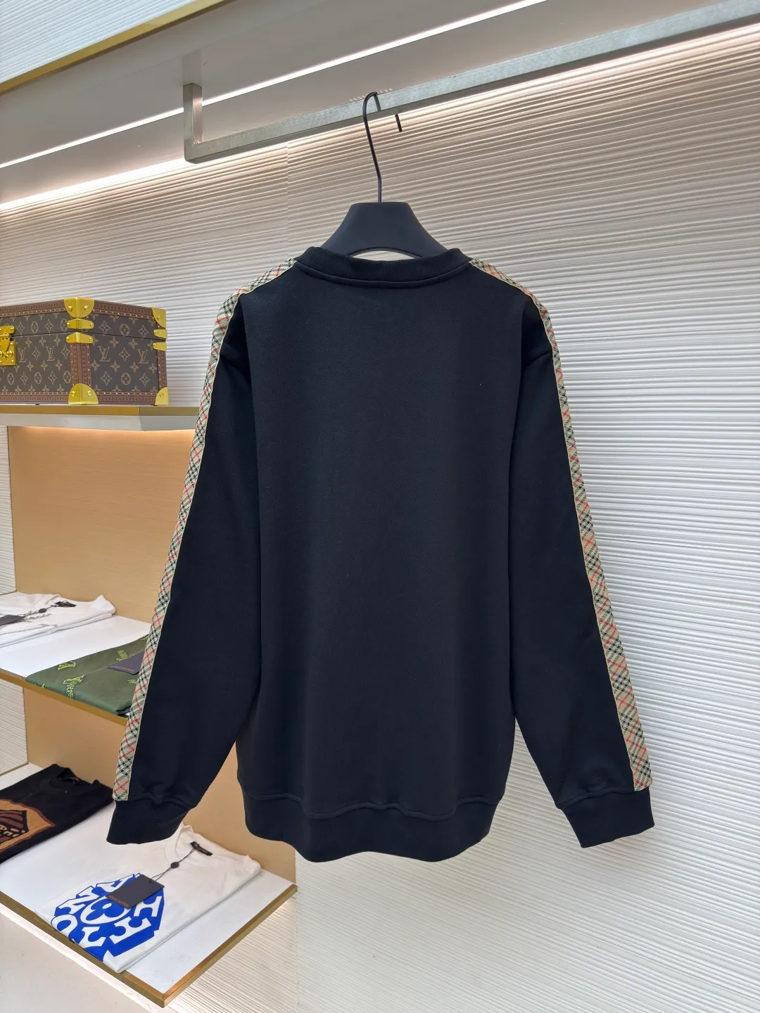 BURBERRY webbing trim round neck sweatshirt ●Authentic product: purchased and developed by 6143 ●Item number: 1680513-A85 ●Fabric: single-sided fish scale fabric ●Technology: selvedge production ●Version: fitted version ●Weight: about 666 grams ●Size: S-M-L-XL ●Description: A single-sided fish-scale cloth fabric woven with cotton as the base. The front is a smooth knitted surface, and the skin-contacting surface is formed into three-dimensional terry by the floating thread knitting technology of the knitting machine, which increases the fluffiness and has a delicate touch. The terry structure absorbs a large amount of water and evaporates quickly, so it is not easy to loosen and deform after repeated washing. By actively interfering with the shrinkage potential of cotton fibers, the fabric is able to transition from changeable to stable, improving dimensional stability while being less prone to deformation and wrinkles. The monochrome flat embroidery on the chest uses the high-precision calculation system of the computer embroidery machine to control the coordinated operation of the machine head, needle bar, and thread spool. The fabric frame moves accurately in the horizontal and vertical directions to form a stitch track. The upper and lower thread tensions are adjusted to ensure that the stitches are smooth and free of floating threads, forming a fine pattern with an error of ±0.1mm. The overall wiring is straight and delicate, the fabric is comfortable and soft, and the color is consistent without color difference. It can be matched with the same style to create a fashionable look and control various occasions. Customized accessories, complete with three standards, same style for men and women!