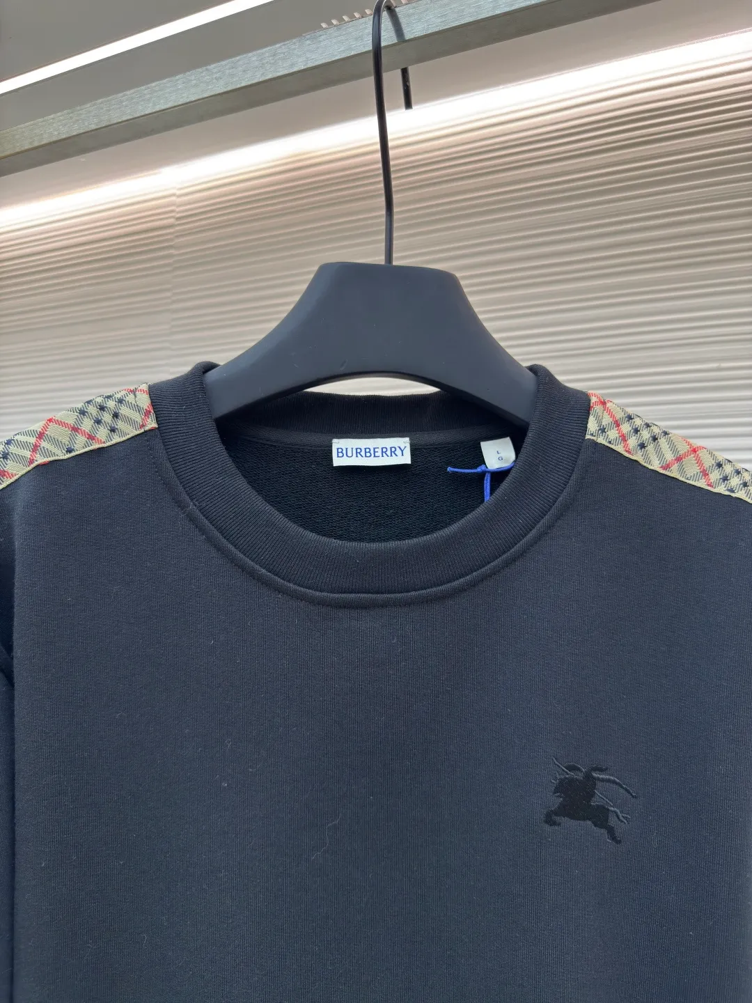 BURBERRY webbing trim round neck sweatshirt ●Authentic product: purchased and developed by 6143 ●Item number: 1680513-A85 ●Fabric: single-sided fish scale fabric ●Technology: selvedge production ●Version: fitted version ●Weight: about 666 grams ●Size: S-M-L-XL ●Description: A single-sided fish-scale cloth fabric woven with cotton as the base. The front is a smooth knitted surface, and the skin-contacting surface is formed into three-dimensional terry by the floating thread knitting technology of the knitting machine, which increases the fluffiness and has a delicate touch. The terry structure absorbs a large amount of water and evaporates quickly, so it is not easy to loosen and deform after repeated washing. By actively interfering with the shrinkage potential of cotton fibers, the fabric is able to transition from changeable to stable, improving dimensional stability while being less prone to deformation and wrinkles. The monochrome flat embroidery on the chest uses the high-precision calculation system of the computer embroidery machine to control the coordinated operation of the machine head, needle bar, and thread spool. The fabric frame moves accurately in the horizontal and vertical directions to form a stitch track. The upper and lower thread tensions are adjusted to ensure that the stitches are smooth and free of floating threads, forming a fine pattern with an error of ±0.1mm. The overall wiring is straight and delicate, the fabric is comfortable and soft, and the color is consistent without color difference. It can be matched with the same style to create a fashionable look and control various occasions. Customized accessories, complete with three standards, same style for men and women!